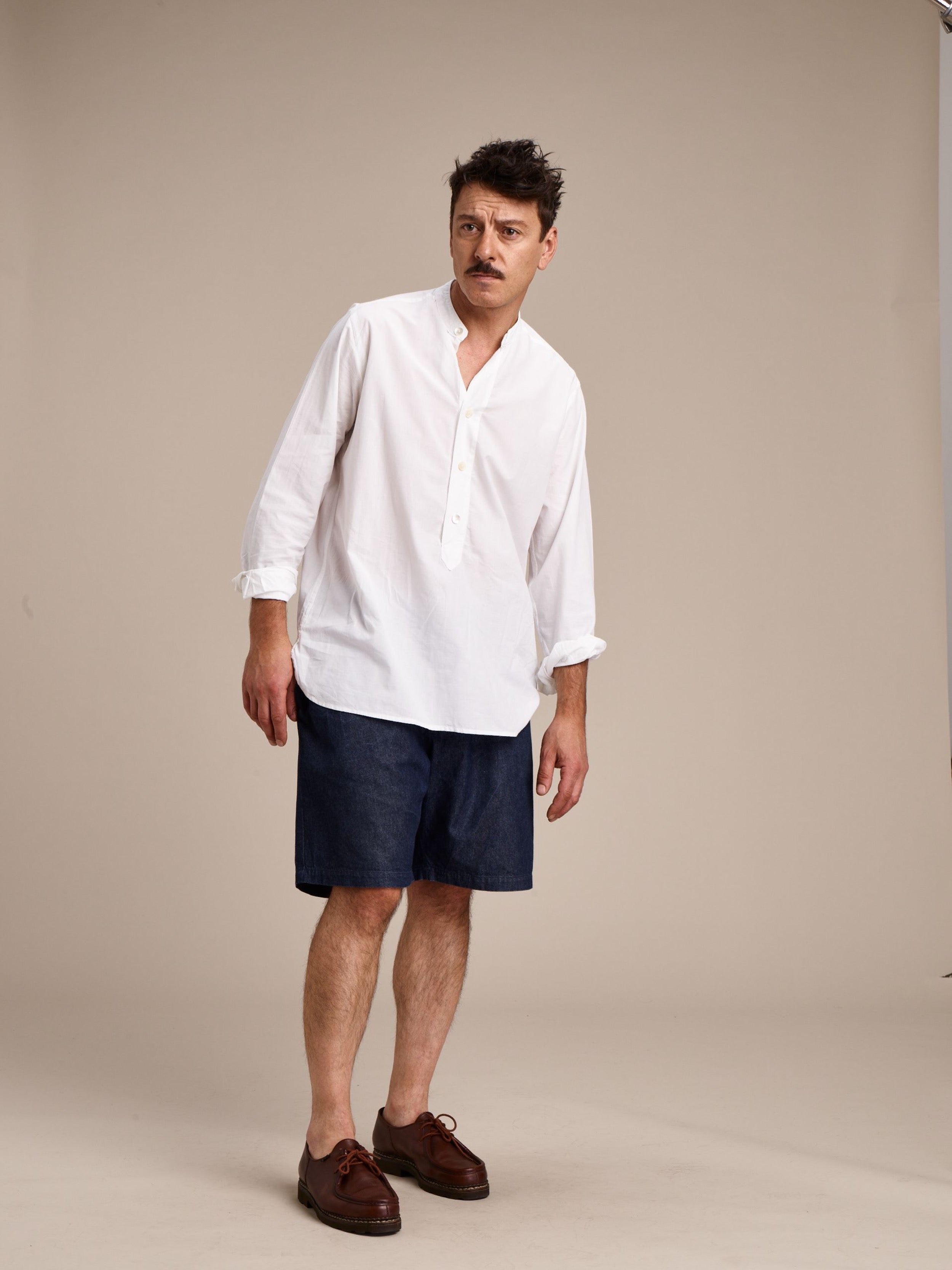 Man wears Carrier Company Lightweight Collarless Shirt with Denim Grandpa Shorts