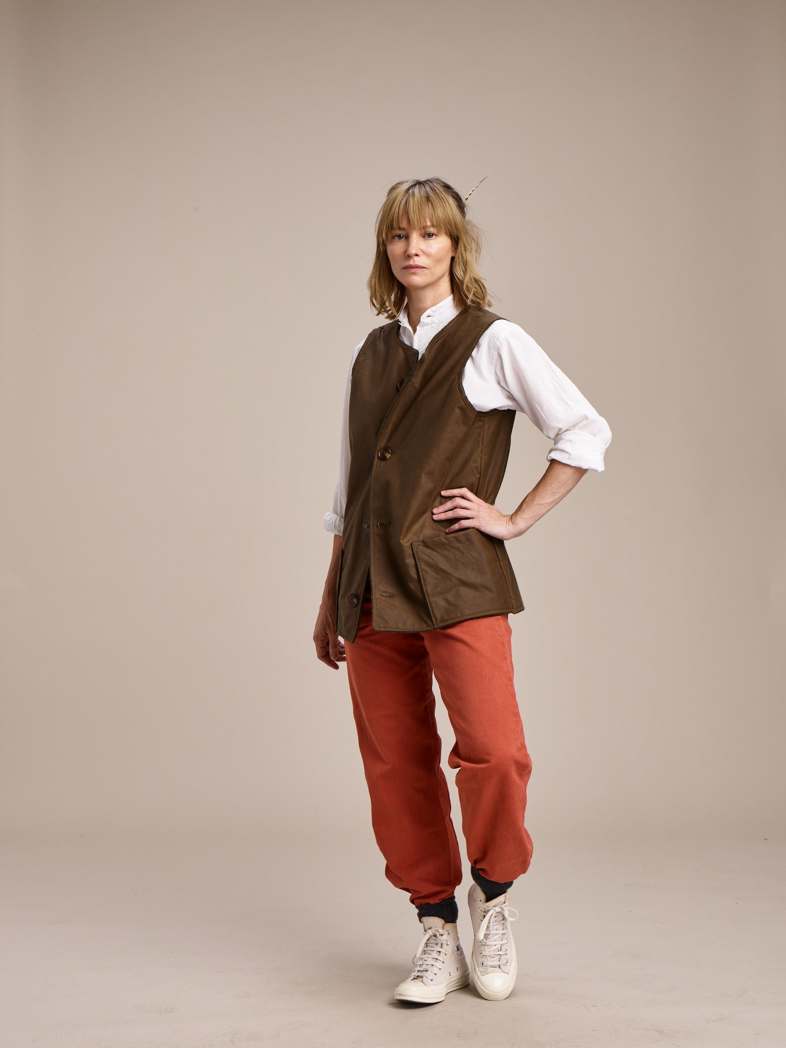 Woman wears Carrier Company Women's Work Trousers in Orange with Wax Jerkin and Lightweight Collarless Shirt