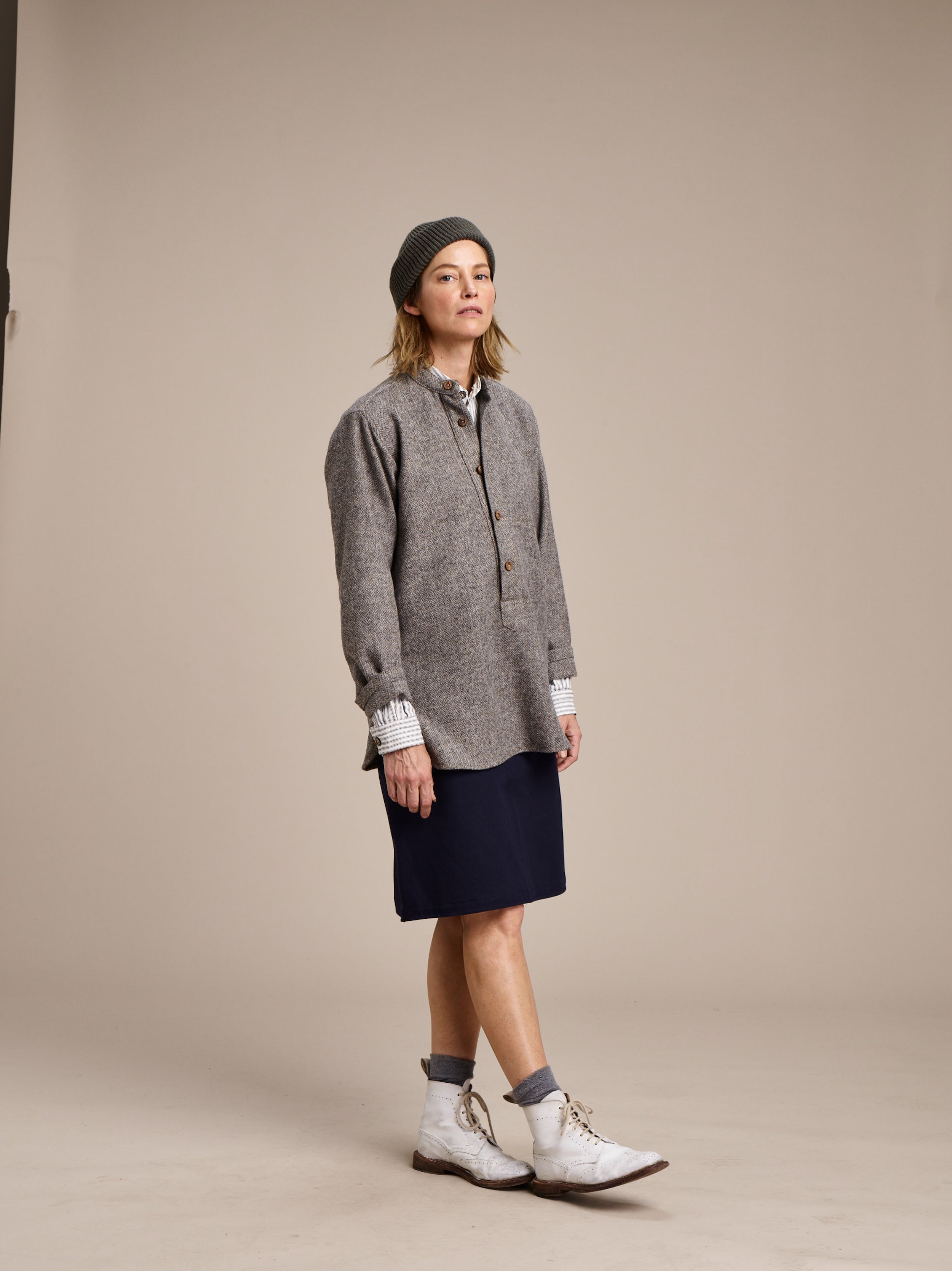 Woman wearing Carrier Company Mum Skirt in Navy with Ticking Work Shirt, Grey Wool Overskirt and Wool Hat in Olive Drab