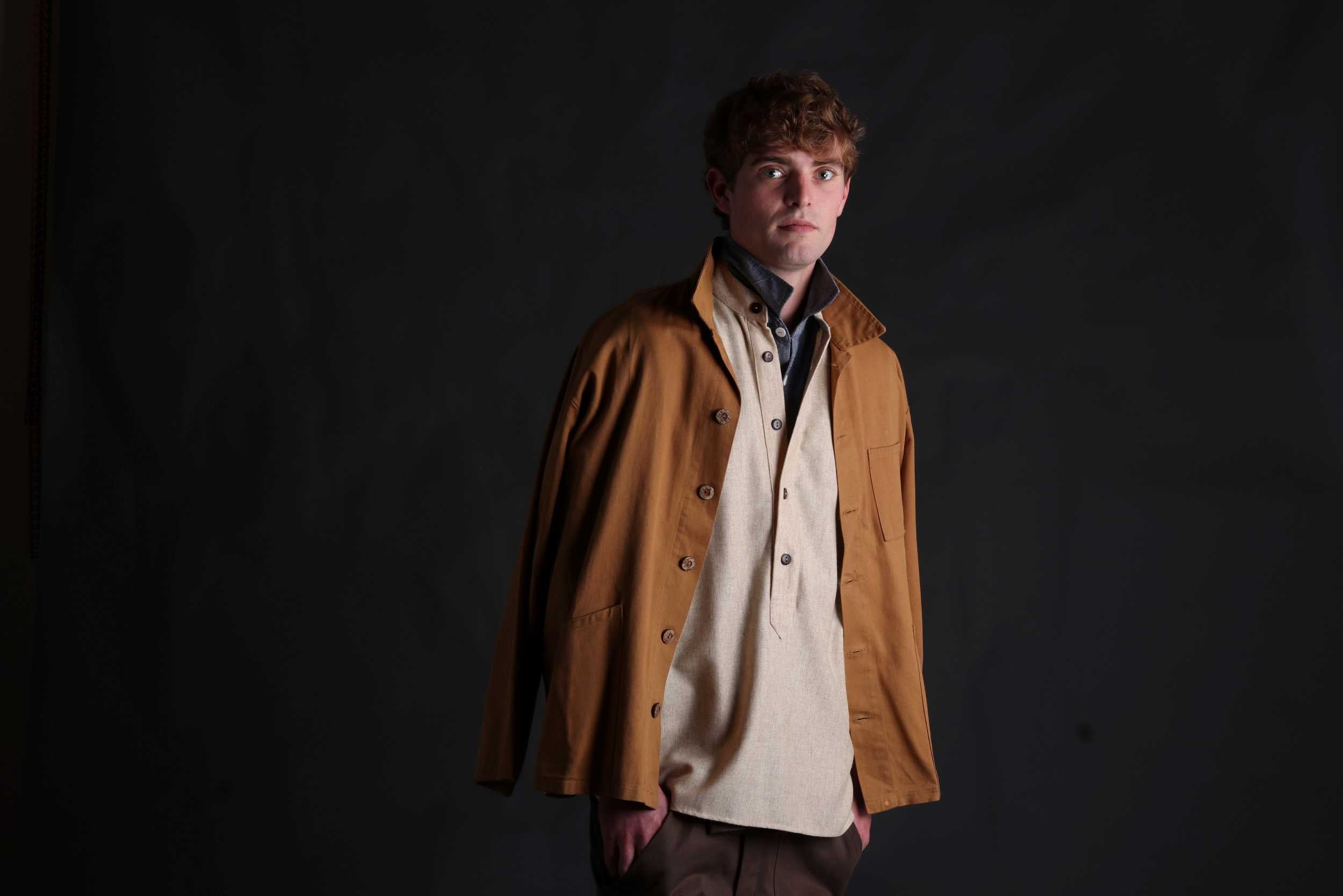 Man wears Carrier Company Wool Overshirt in Barleystraw with Chambray Shirt and Norfolk Work Jacket in Tan