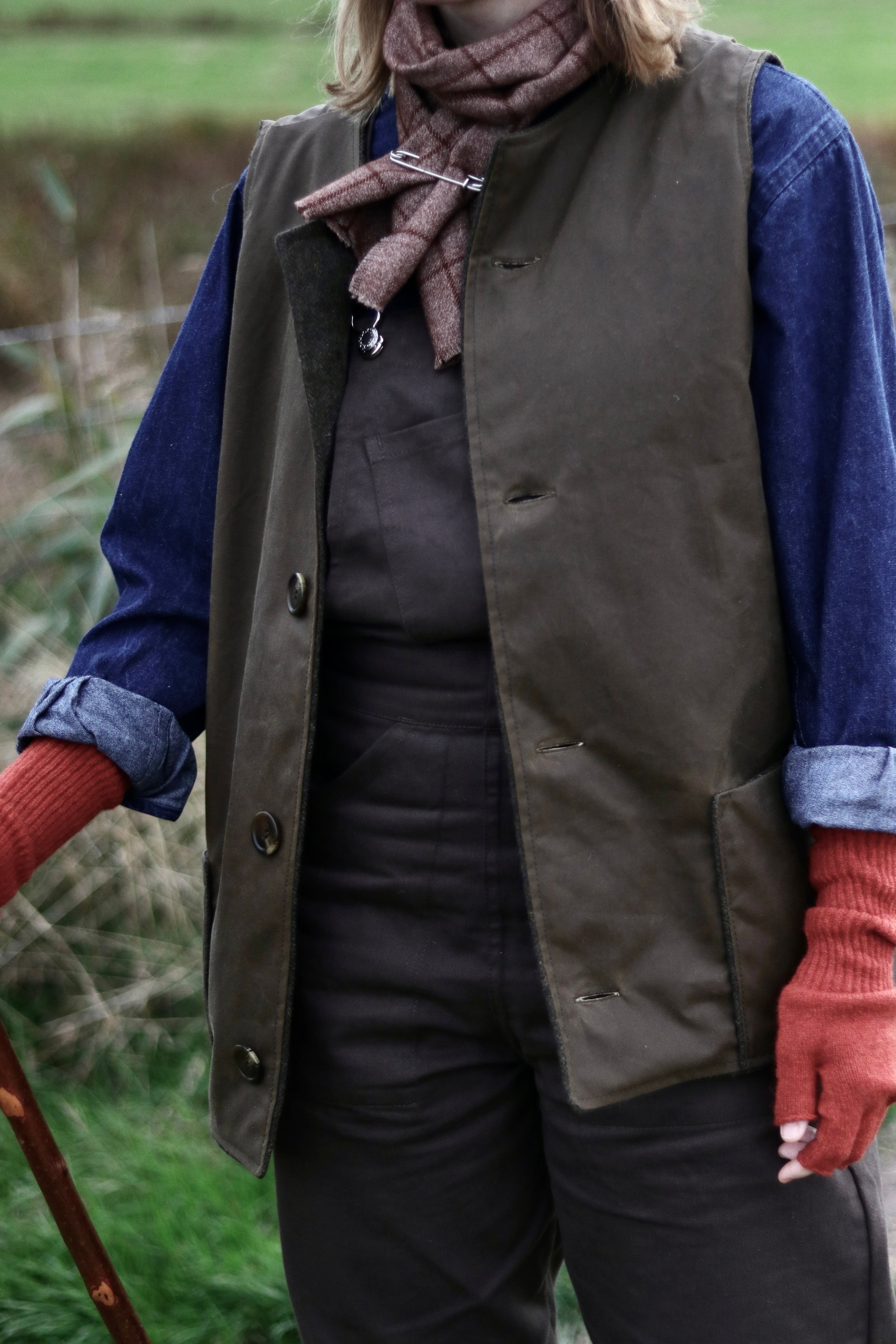 Woman wears Carrier Company Women's Dungarees in Olive with Norfolk Jerkin and Gathering Glove