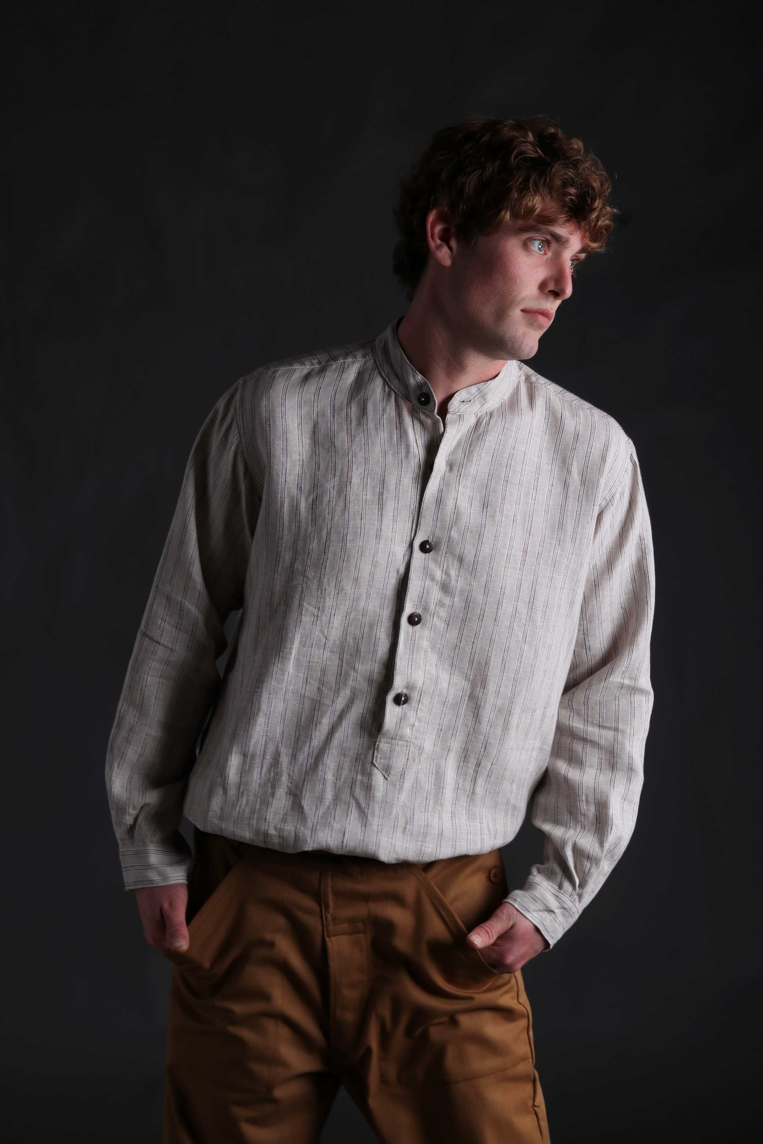 Man wears Carrier Company Collarless Shirt in Natural Linen with Tan Work Trousers