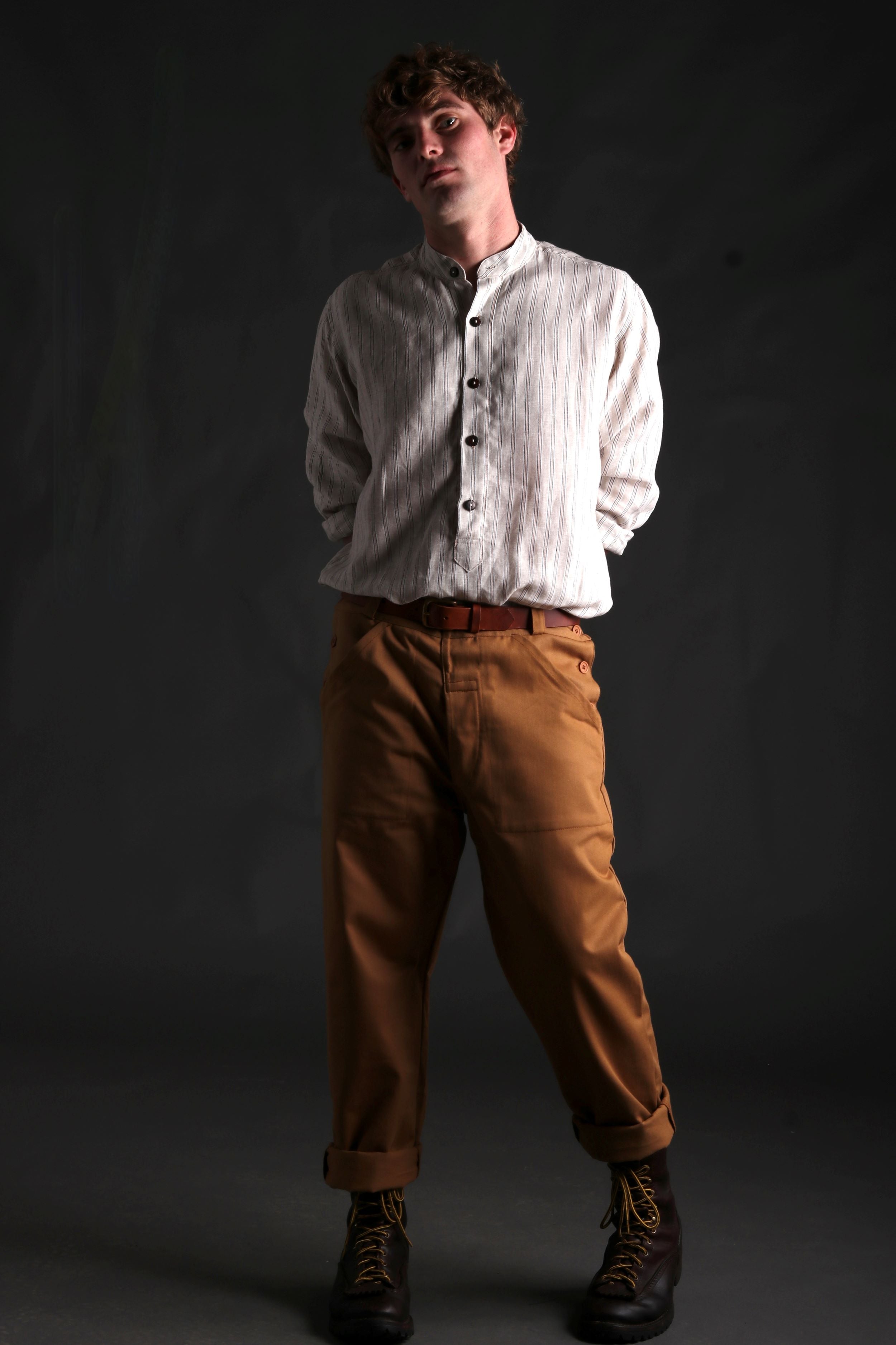 Man wears Carrier Company Collarless Shirt in Natural Linen with Tan Work Trousers