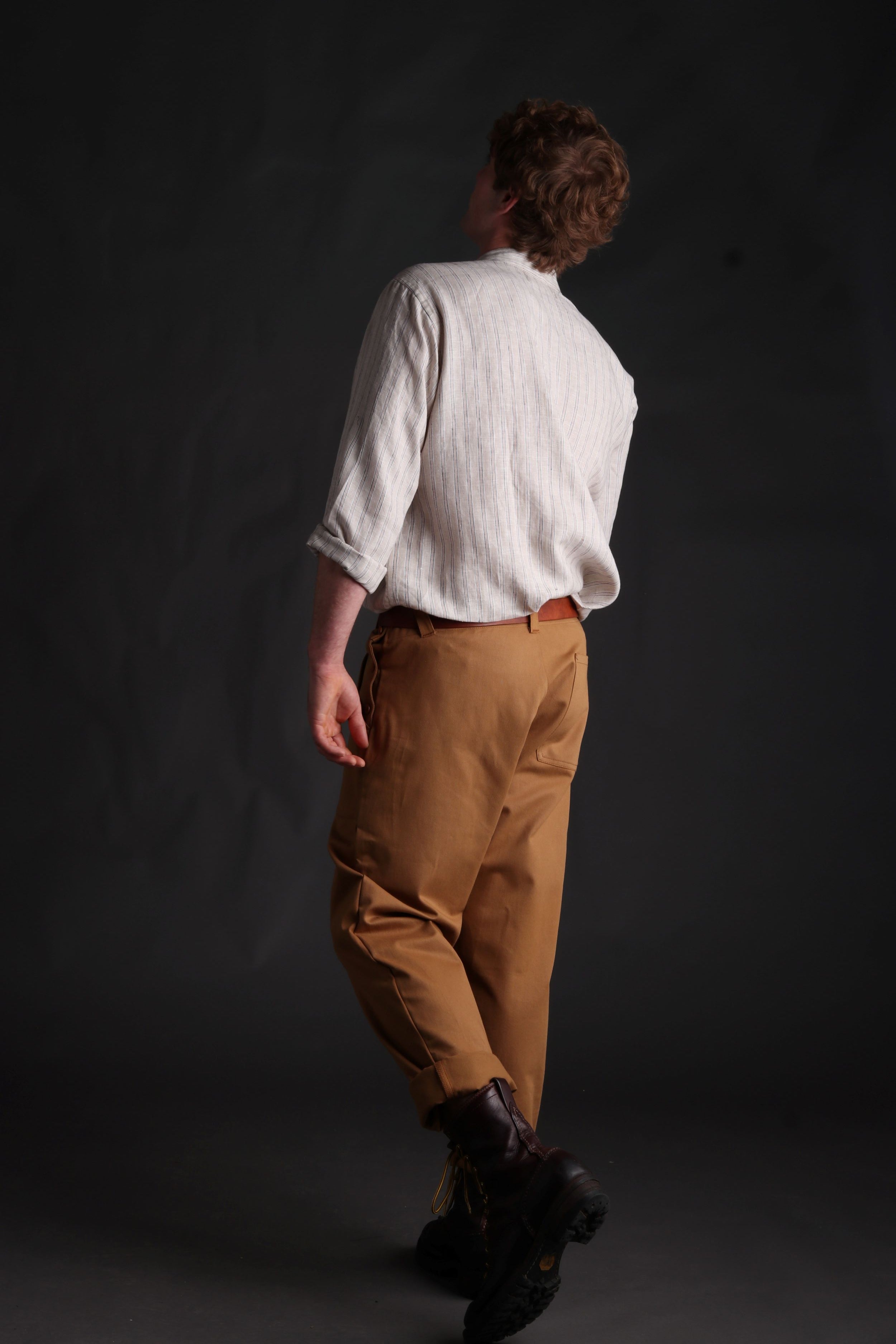Man wears Carrier Company Collarless Shirt in Natural Linen with Tan Work Trousers