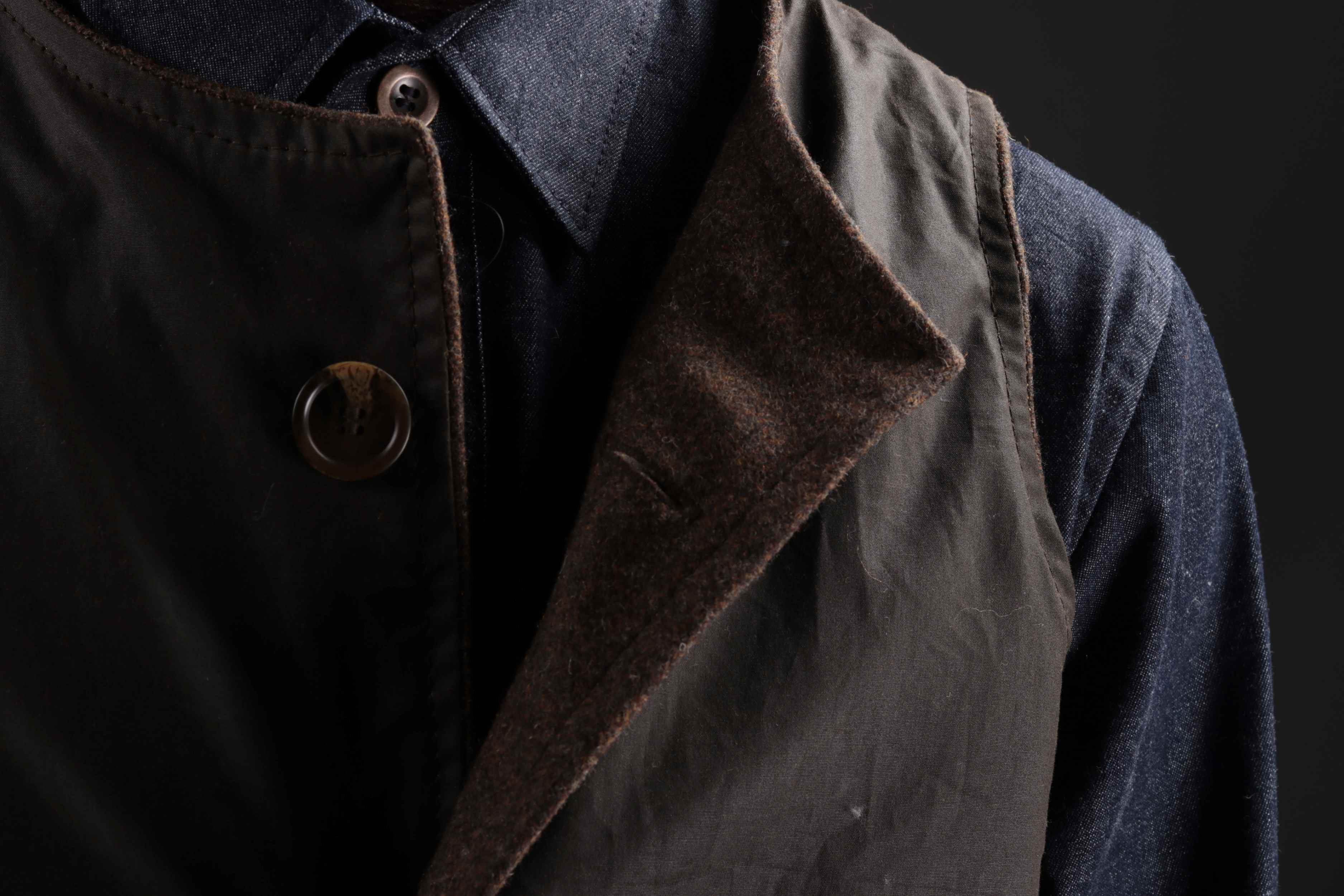 Man wears Norfolk Wax Jerkin in Olive with a Denim Collar Shirt