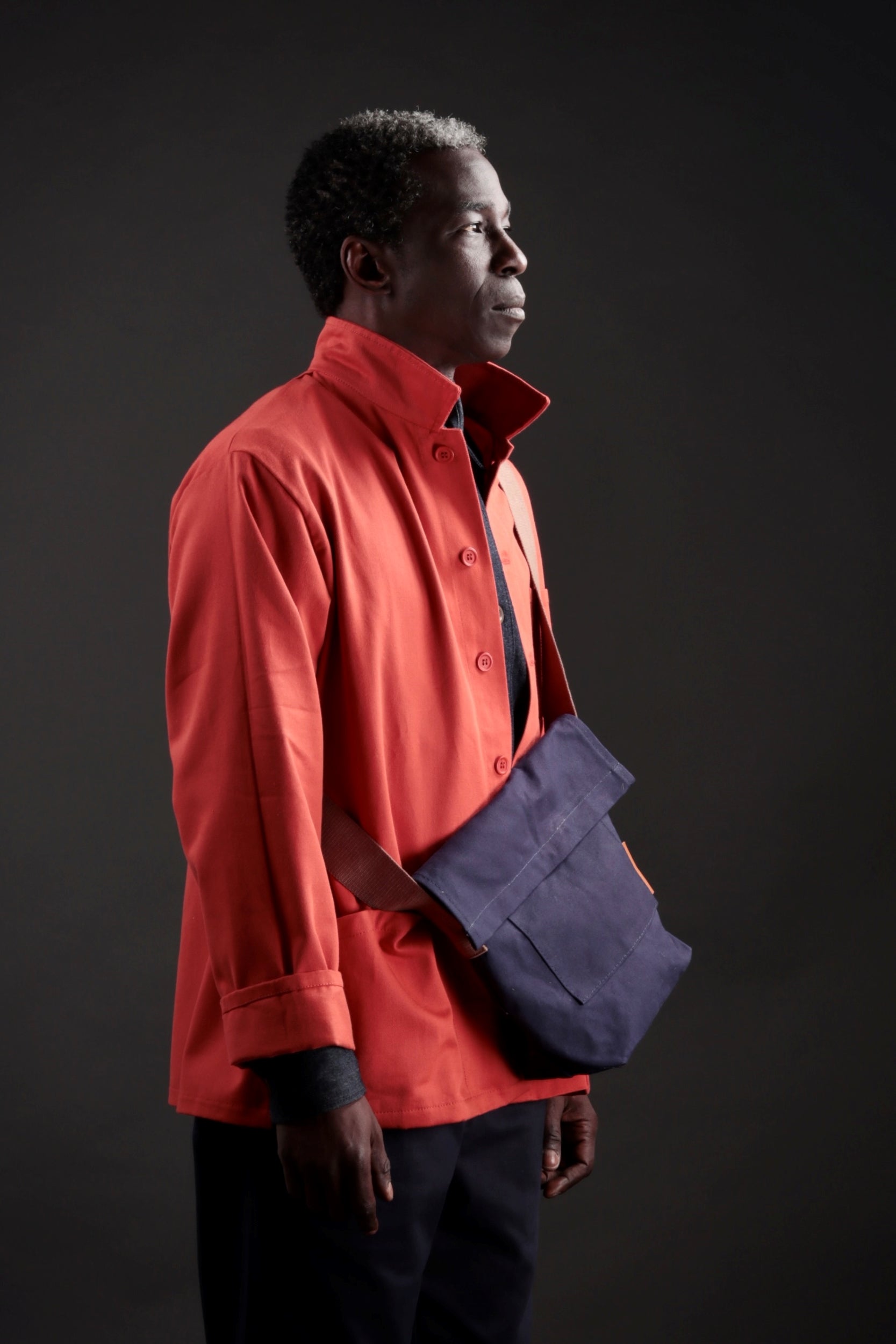 Man carries a Carrier Company Canvas Satchel in Navy