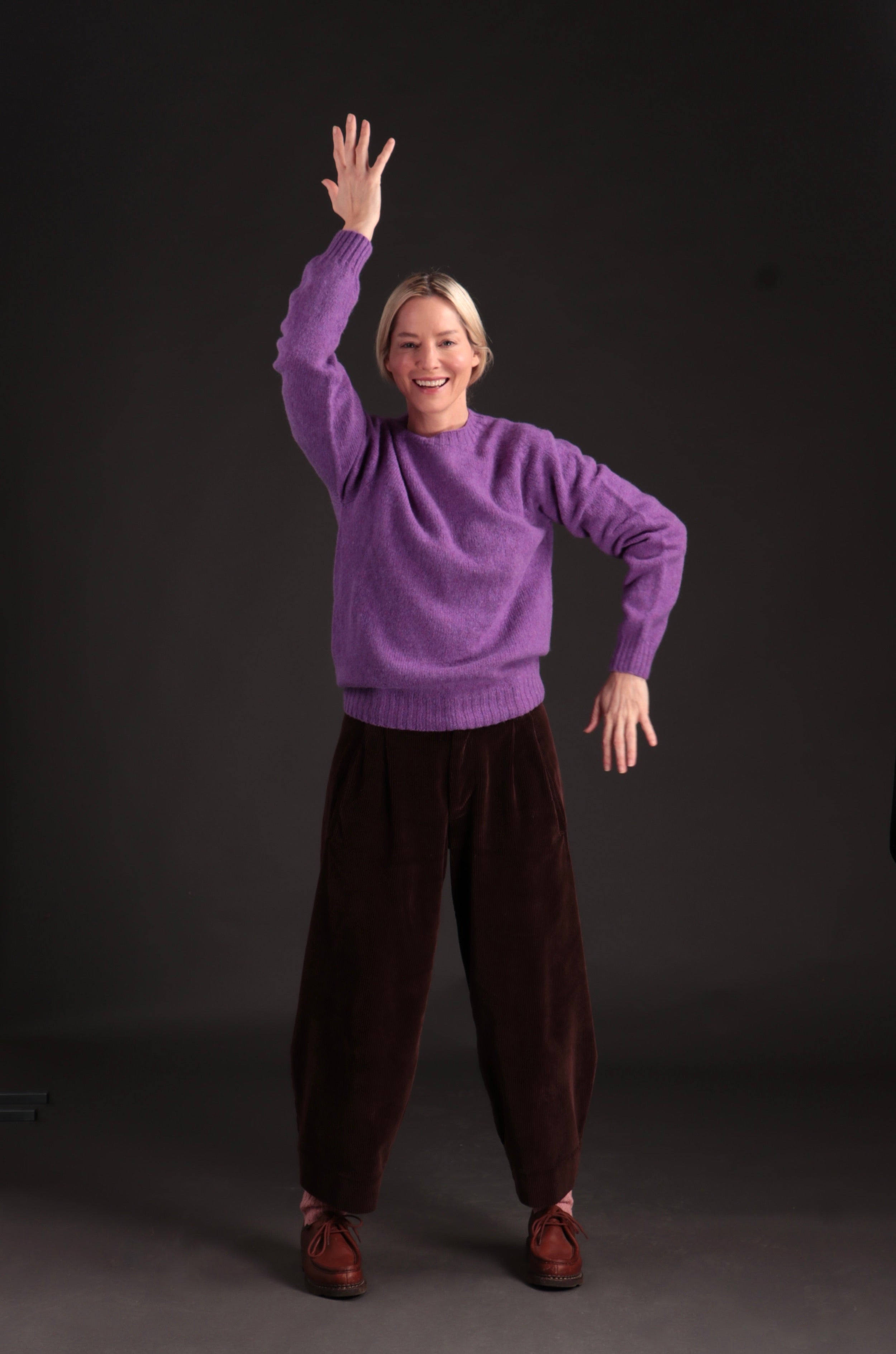 Woman wears Carrier Company Shetland Lambswool Jumper in Allium with Dutch Trouser in Chocolate Corduroy