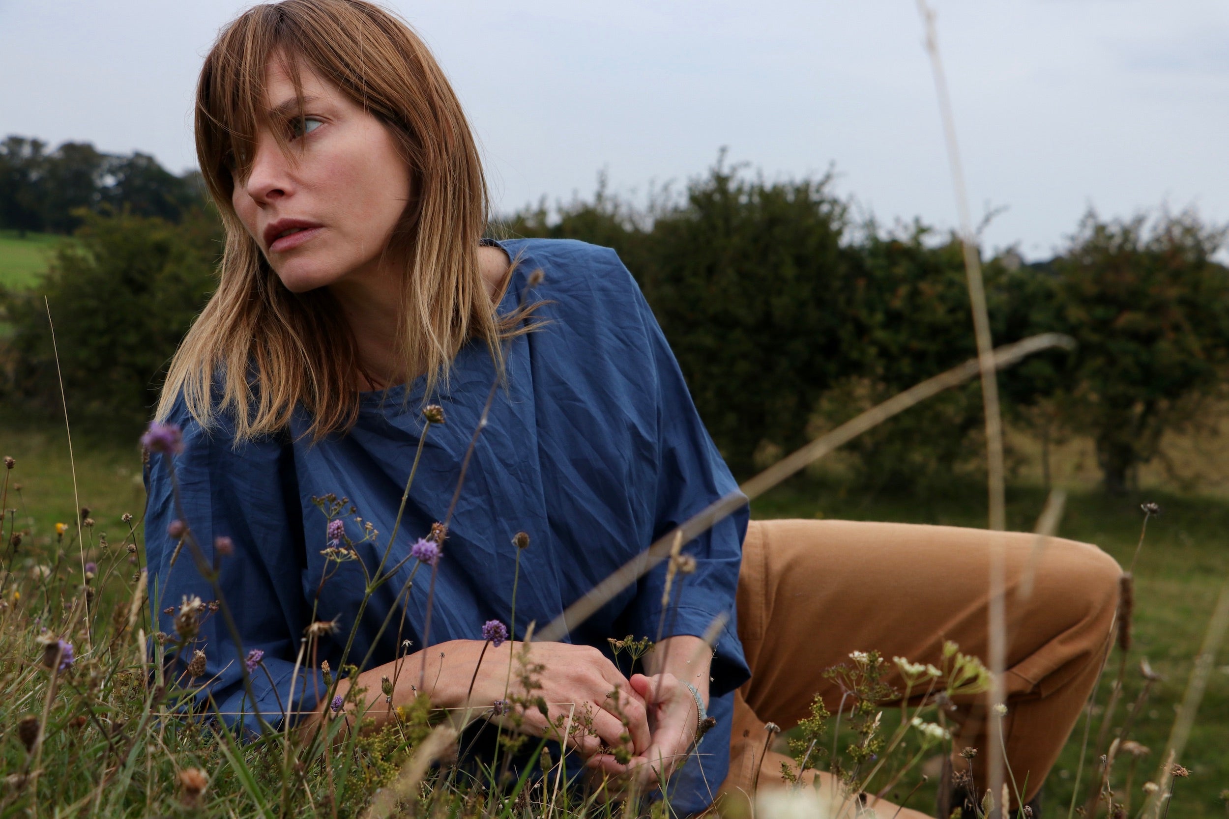 Woman wears Carrier Company Cotton Tee Shirt in Petrol Blue