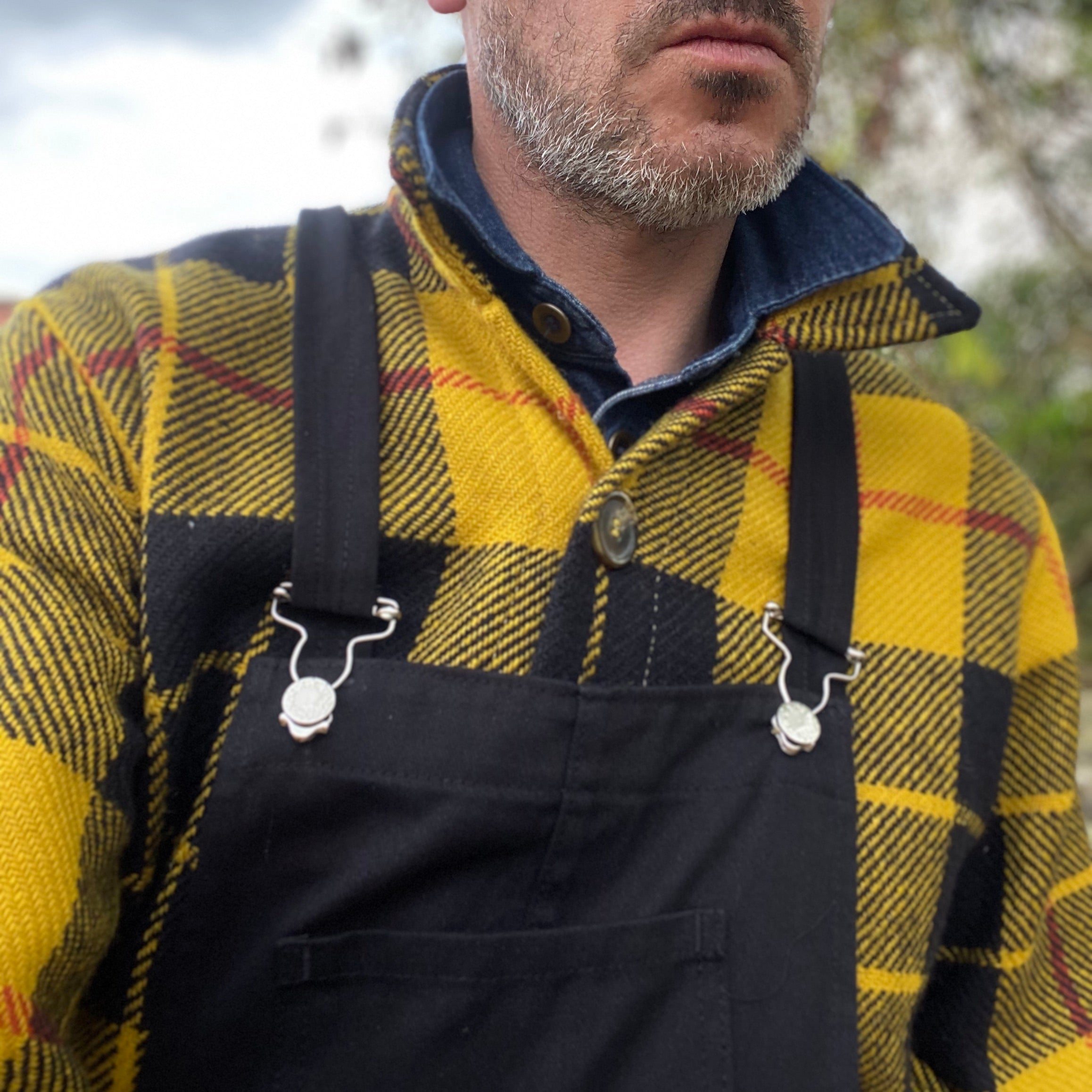 Man wearing Celtic Wool Jacket in Black and Yellow Check with wool hat and black Men's Dungarees