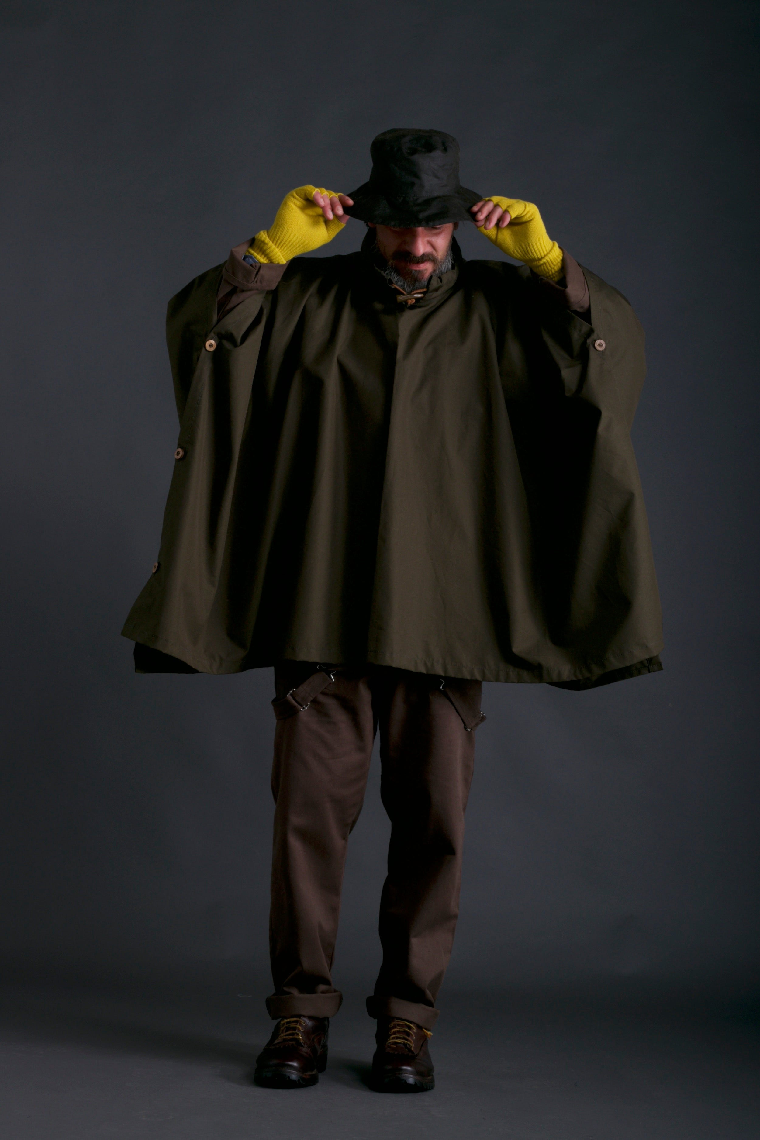 Man wearing Carrier Company Rain Cape with Gathering Gloves, Rain Hat and Olive Dungarees