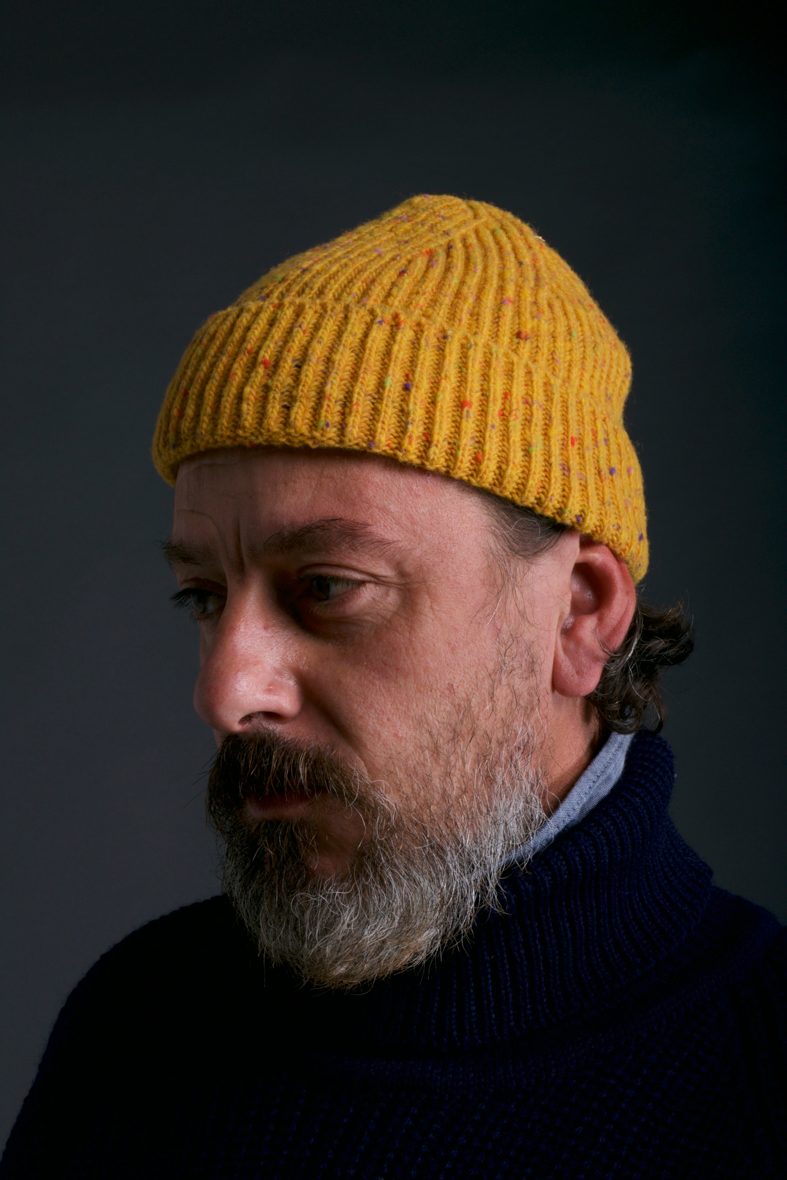 Man wears carrier Company Donegal Wool Hat in Papaya with Navy Fisherman's Jumper
