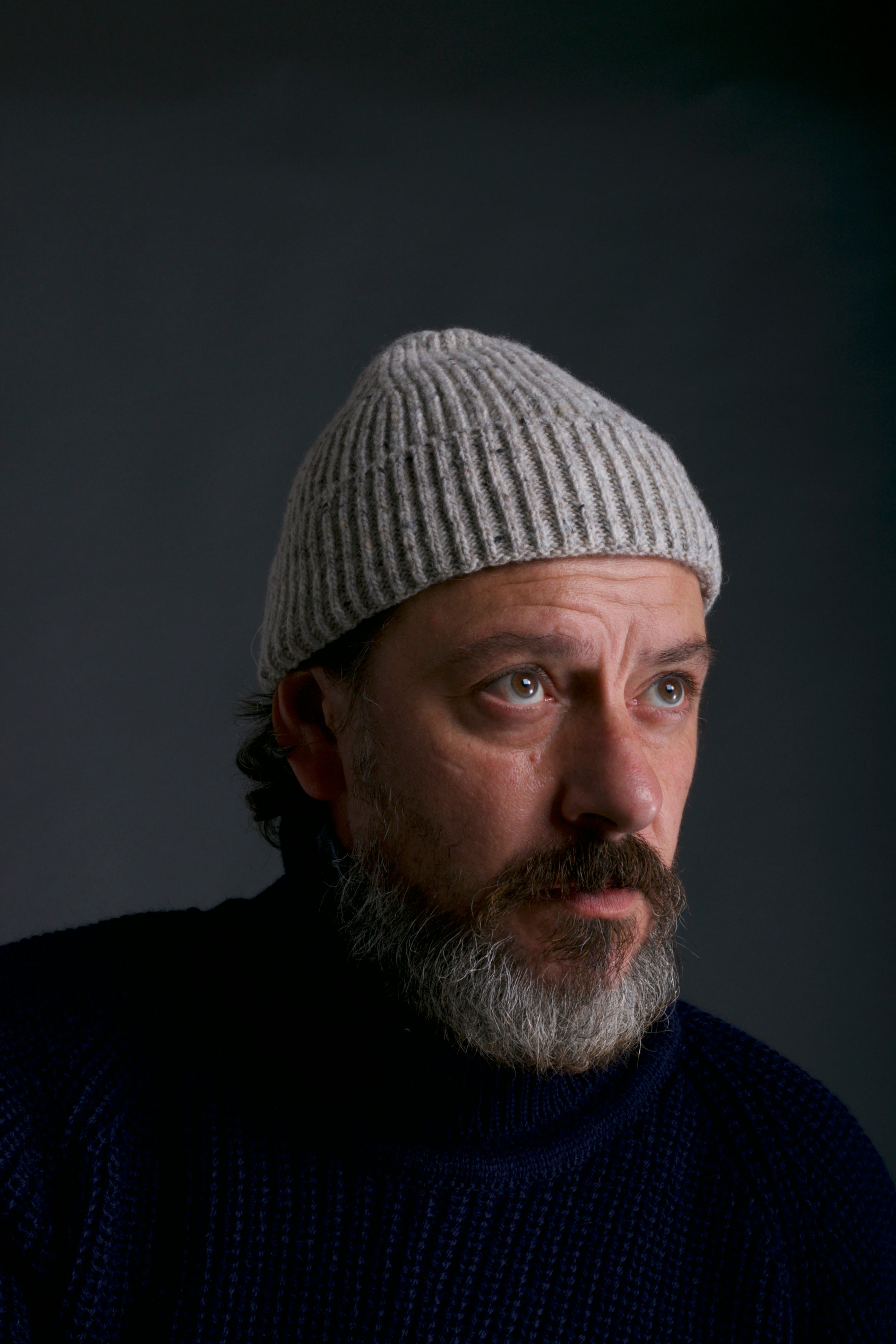 Man wears Carrier Company Donegal Wool Hat in Pale Grey with Navy Fisherman's Jumper