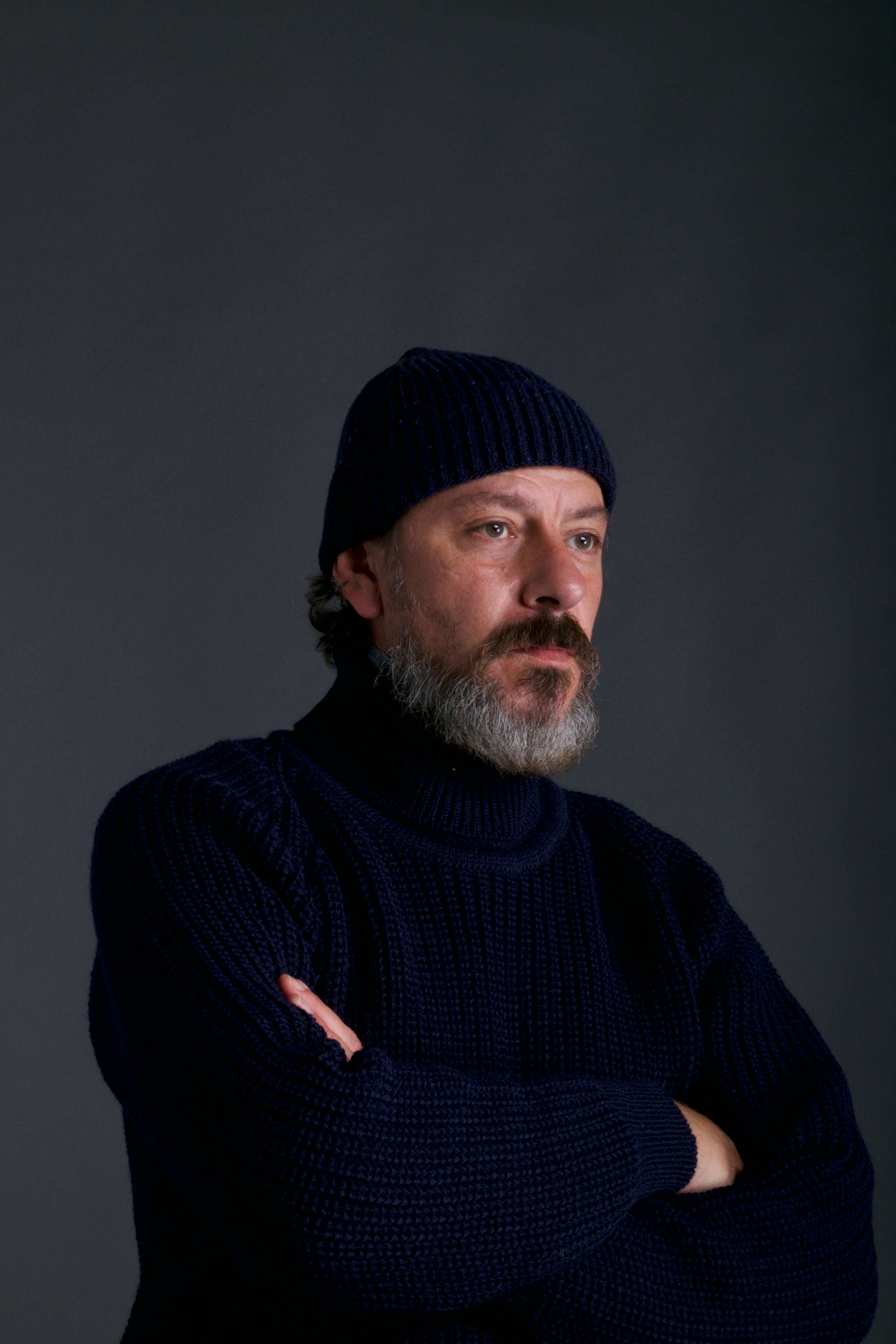 Man wears Carrier Company Donegal Wool Hat in Navy with Navy Fisherman's Jumper