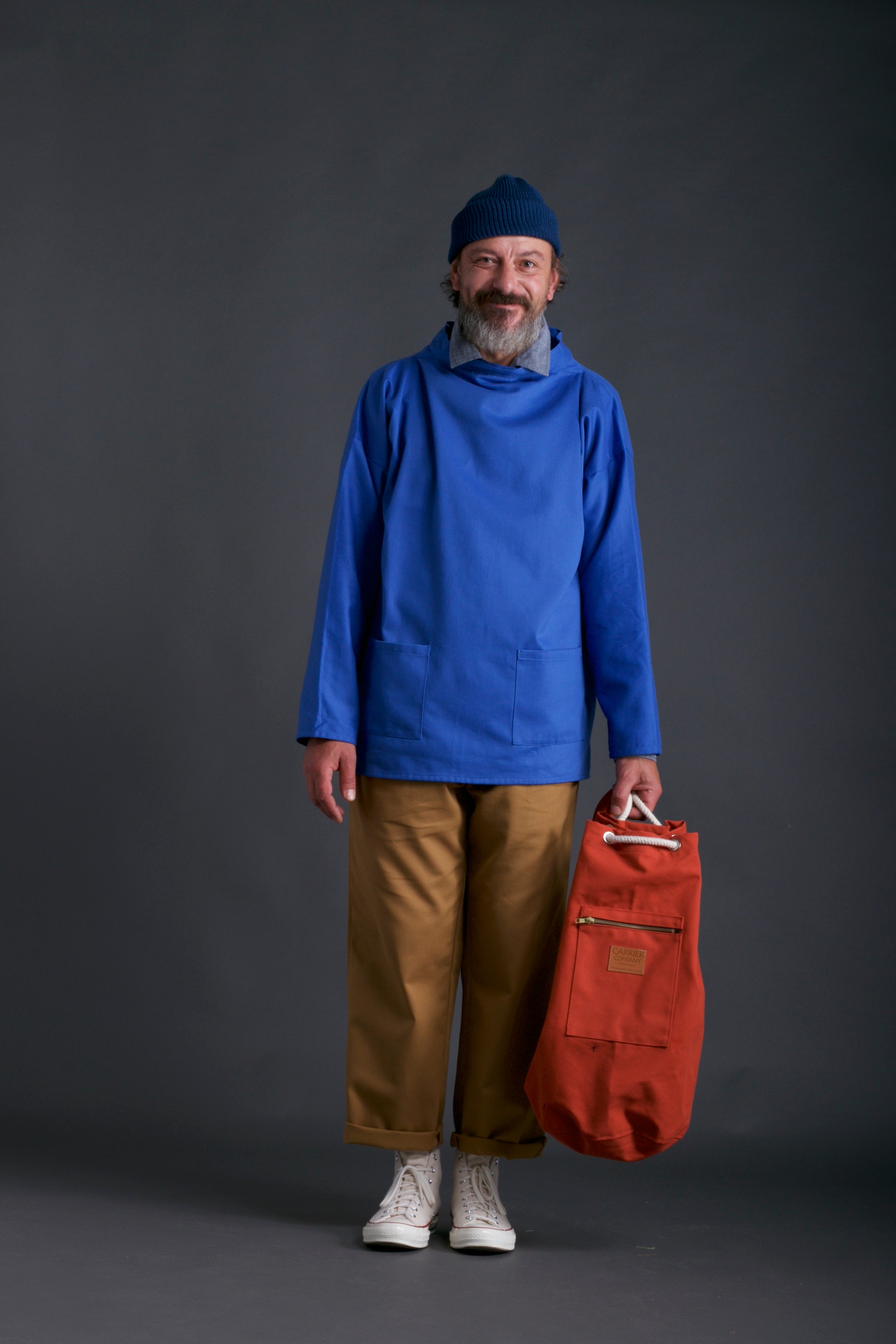 Man wears Carrier Company Traditional Norfolk Slop in Sky Blue with classic Trouser, Chambray Shirt and Wool Hat in Petrol Blue