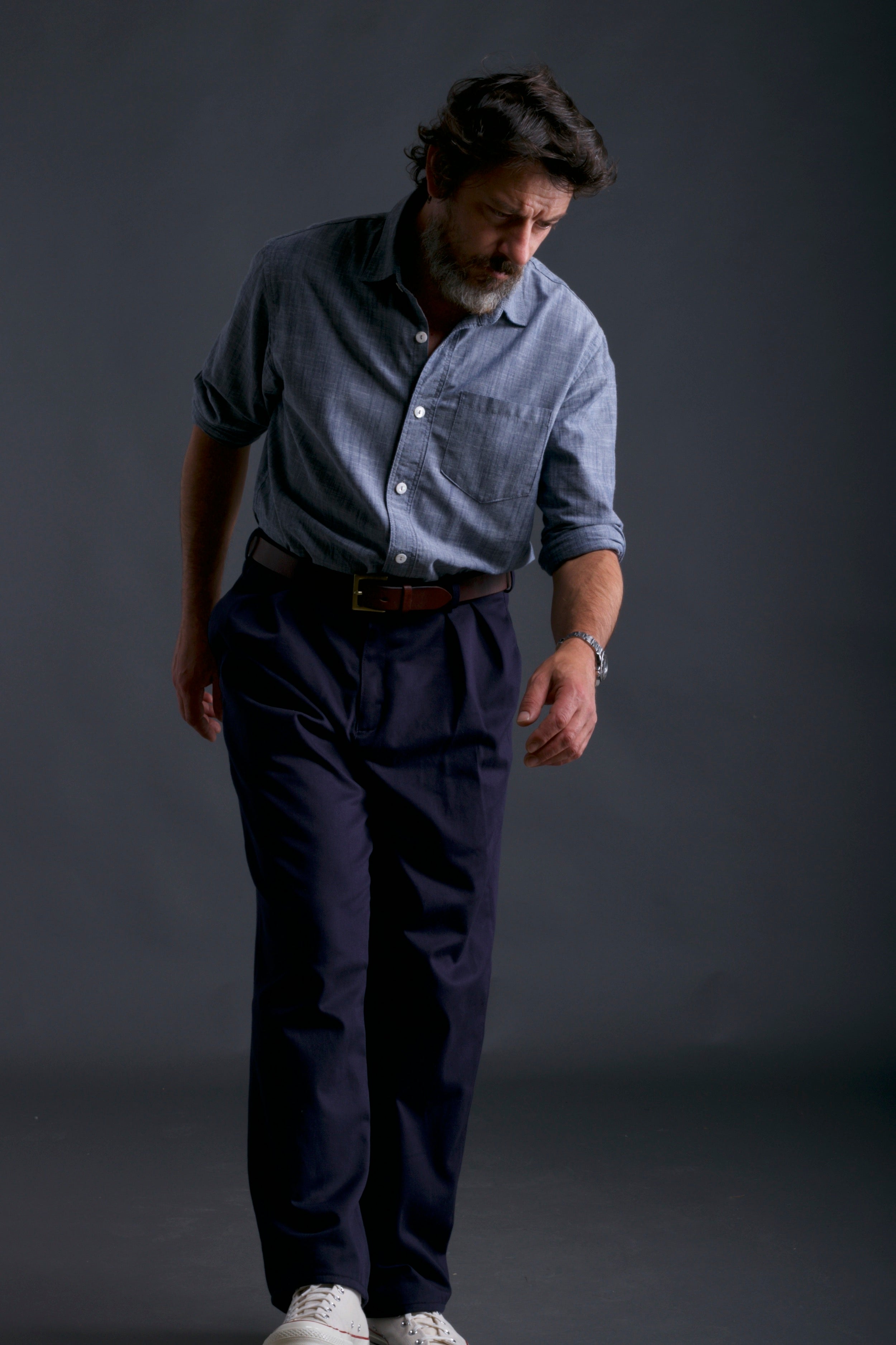 Man wears Carrier Company Chambray Shirt and Classic Trouser in Navy