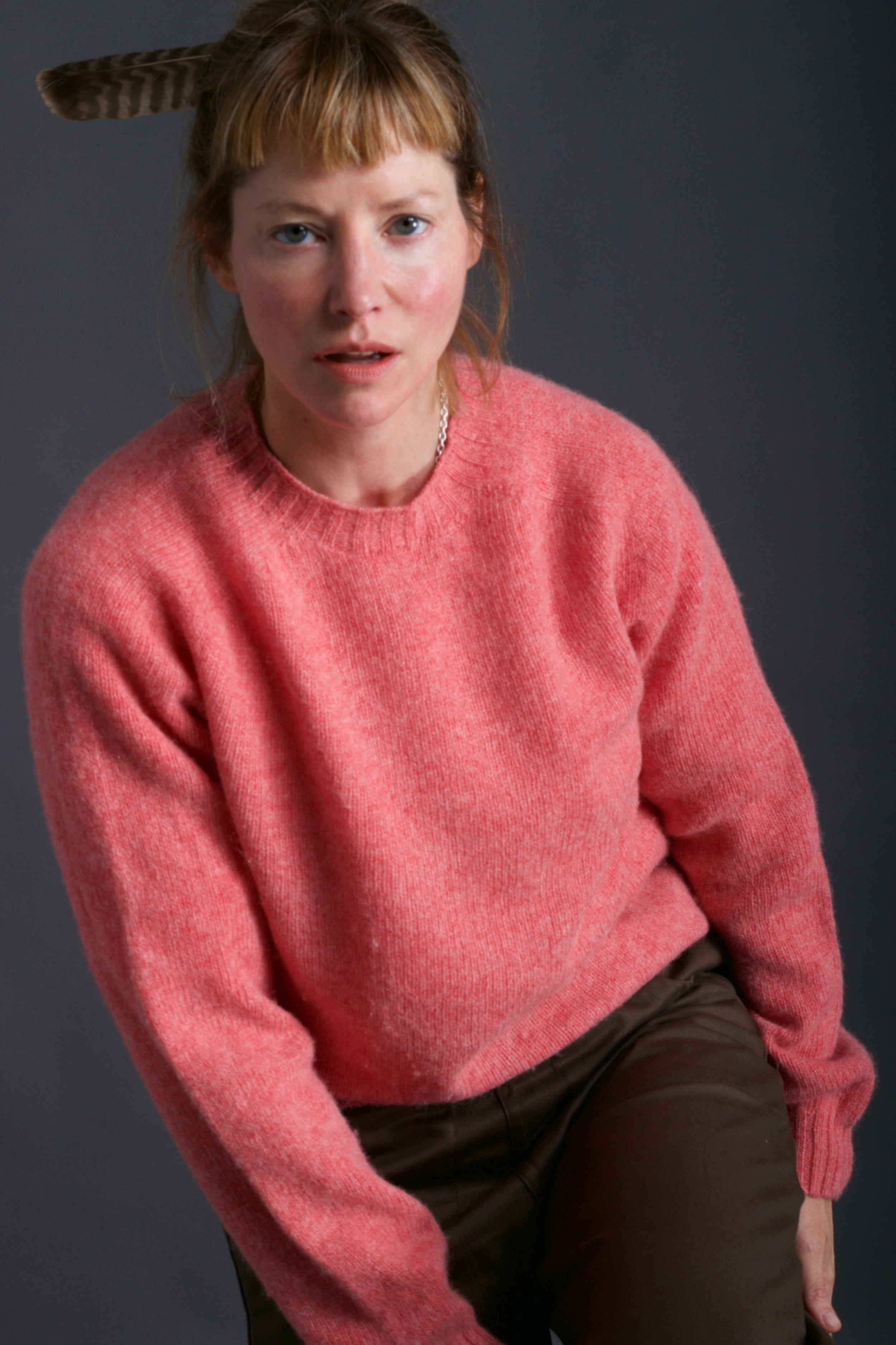 Woman wears Carrier Company Shetland Lambswool Jumper in Salmon with Olive Work Trouser