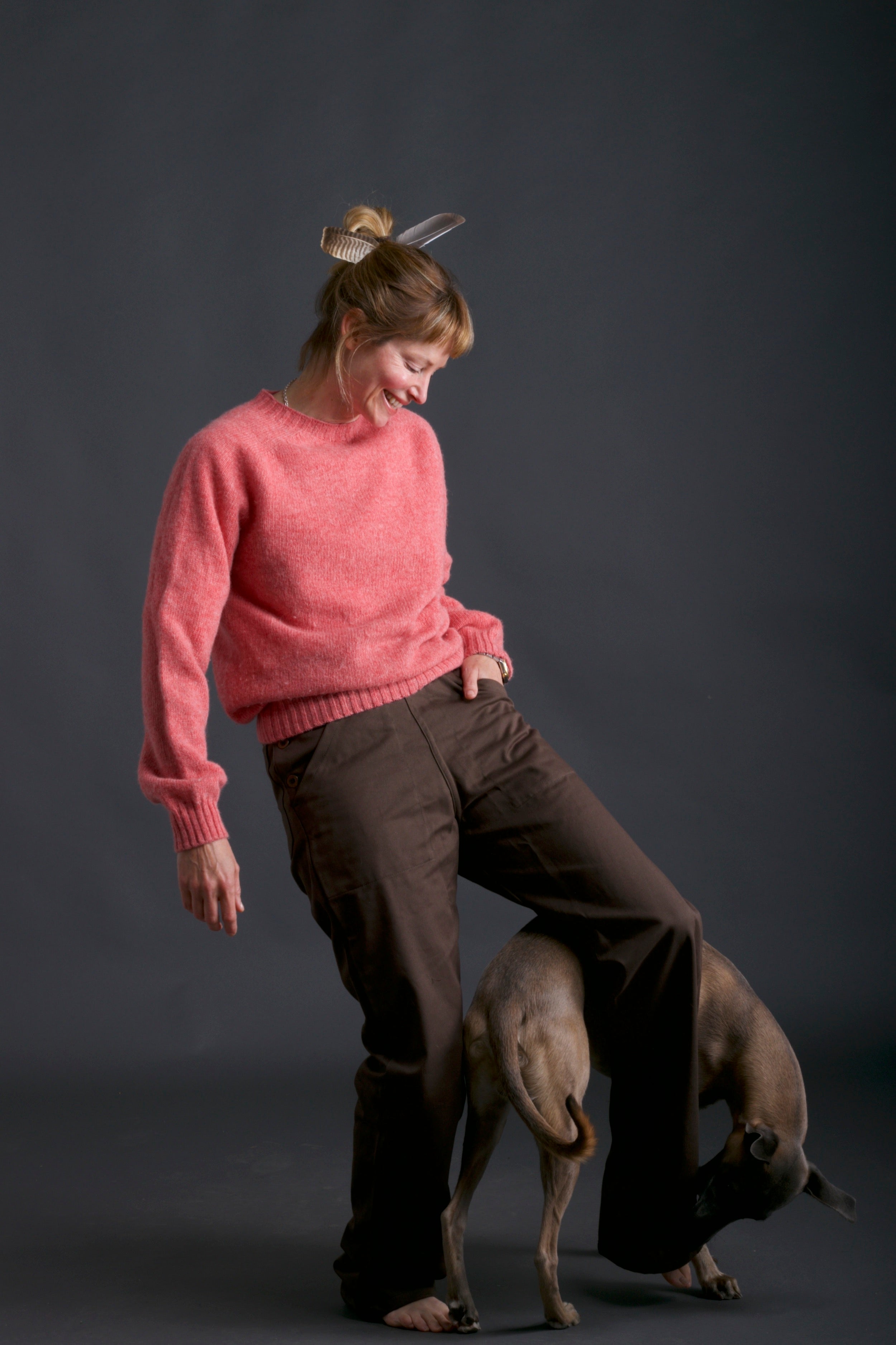 Woman wears Carrier Company Shetland Lambswool Jumper in Salmon and Olive Work Trouser