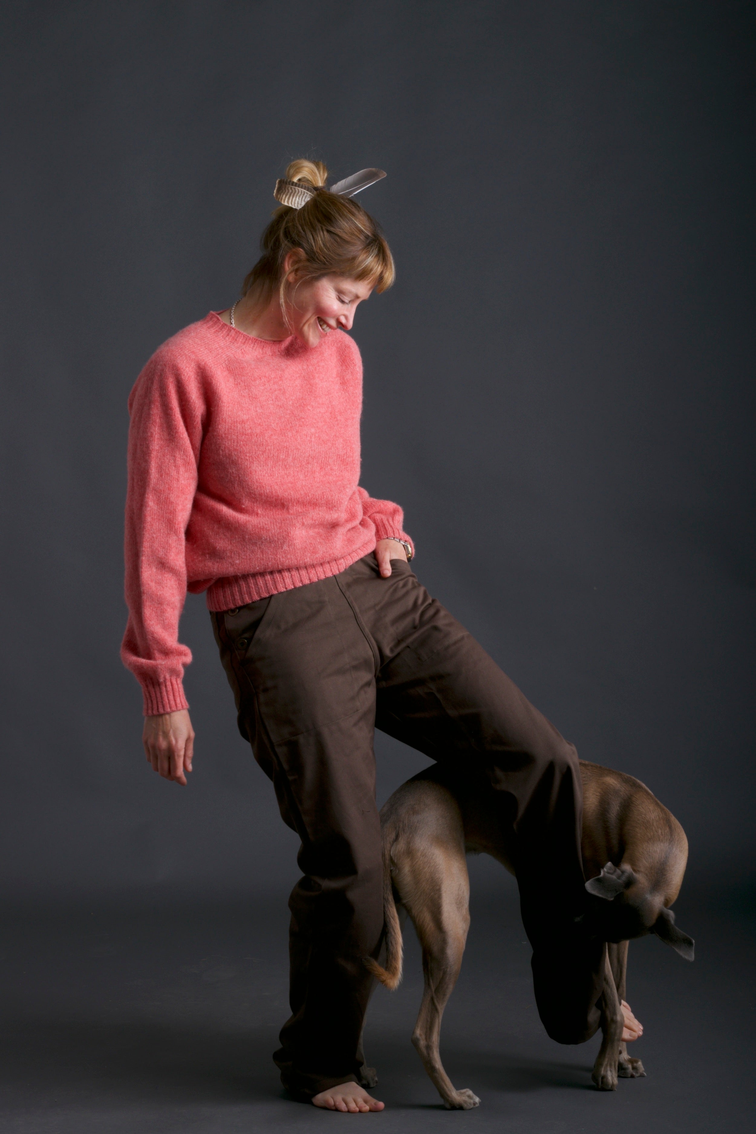 Woman wears Carrier Company Shetland Lambswool Jumper in Salmon with Olive Work Trouser