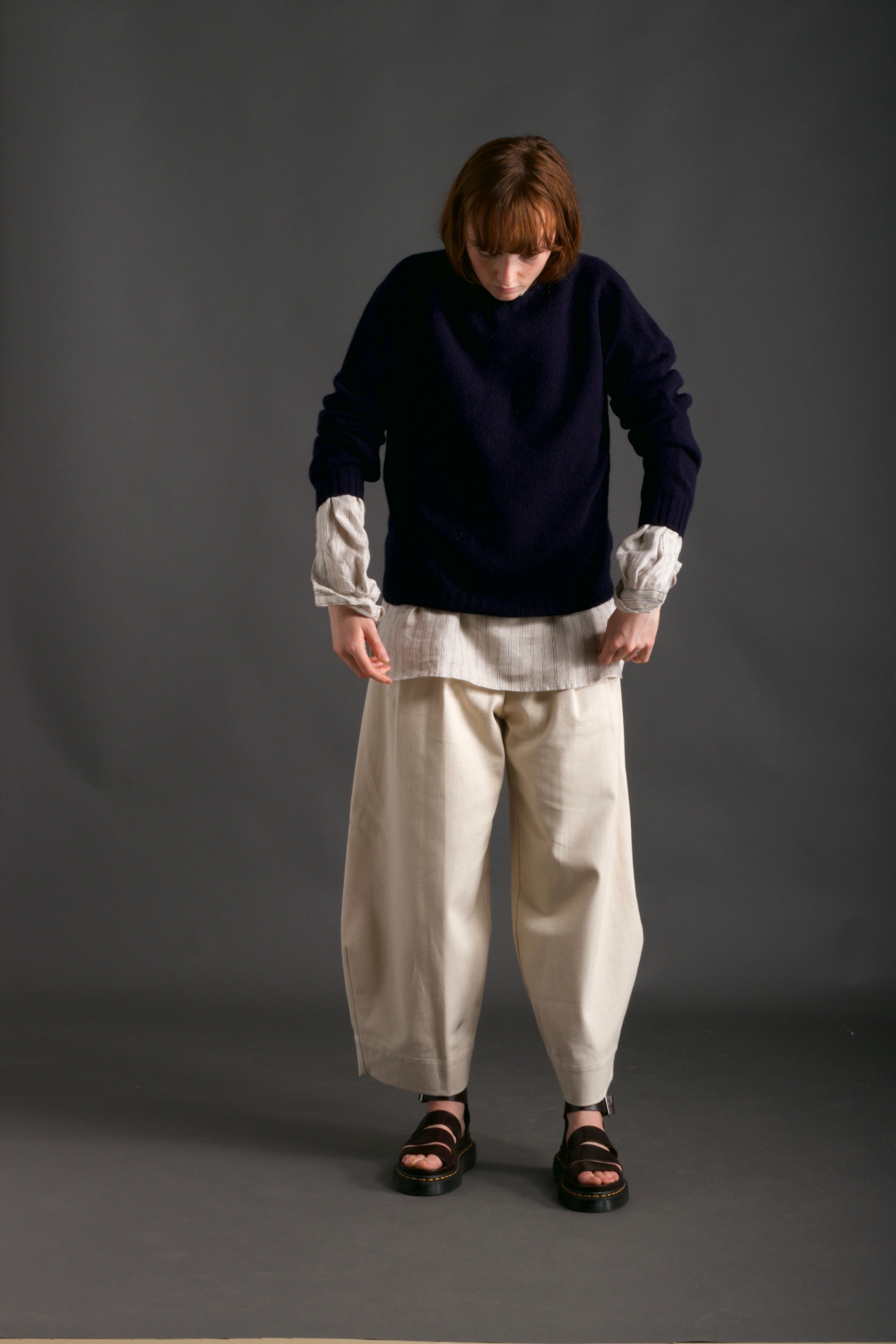 Woman wears Carrier Company Shetland Lambswool Jumper in Navy with Dutch Trouser in Seeded Denim