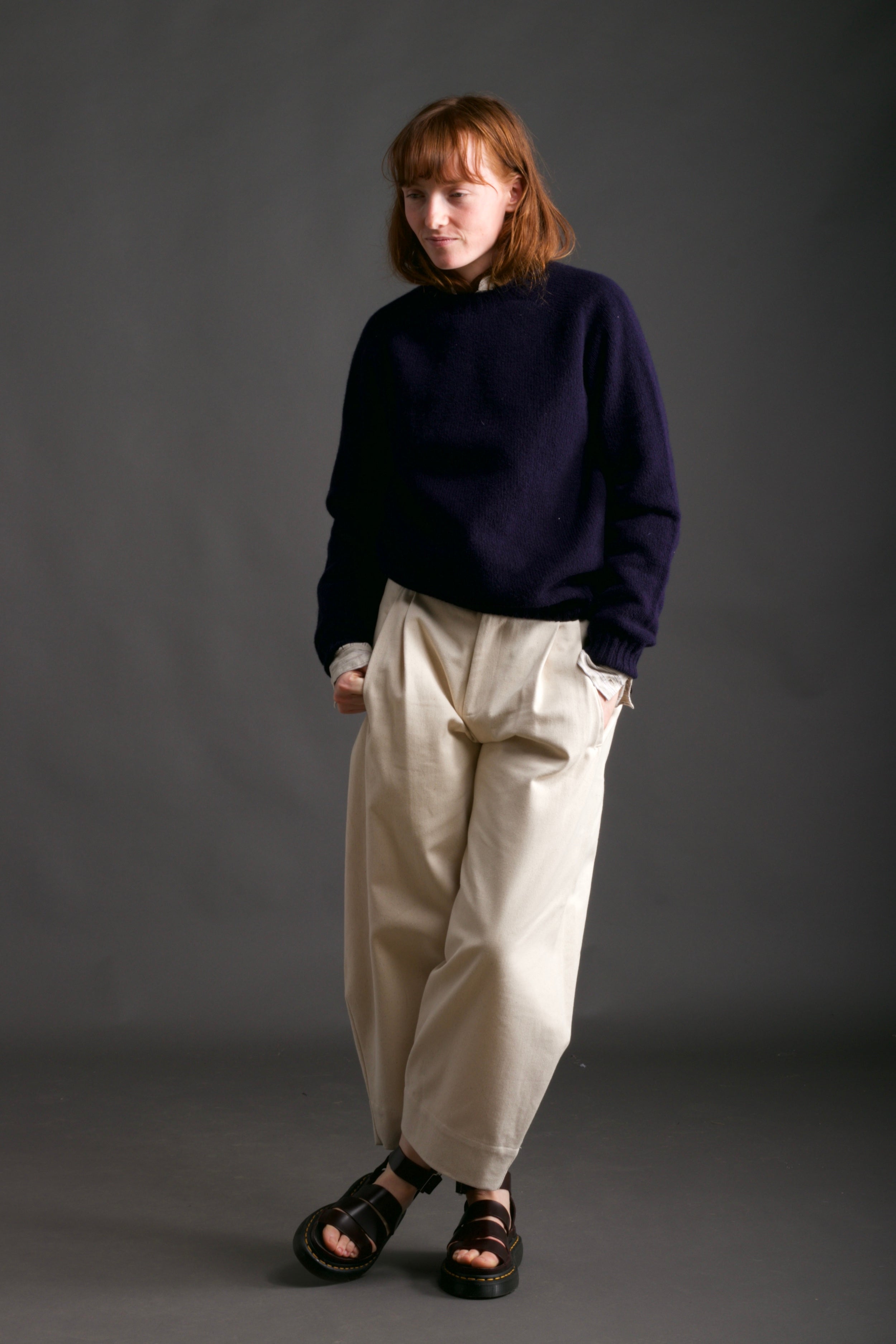 Woman wears Carrier Company Shetland Lambswool Jumper in Navy with Dutch Trouser in Seeded Denim