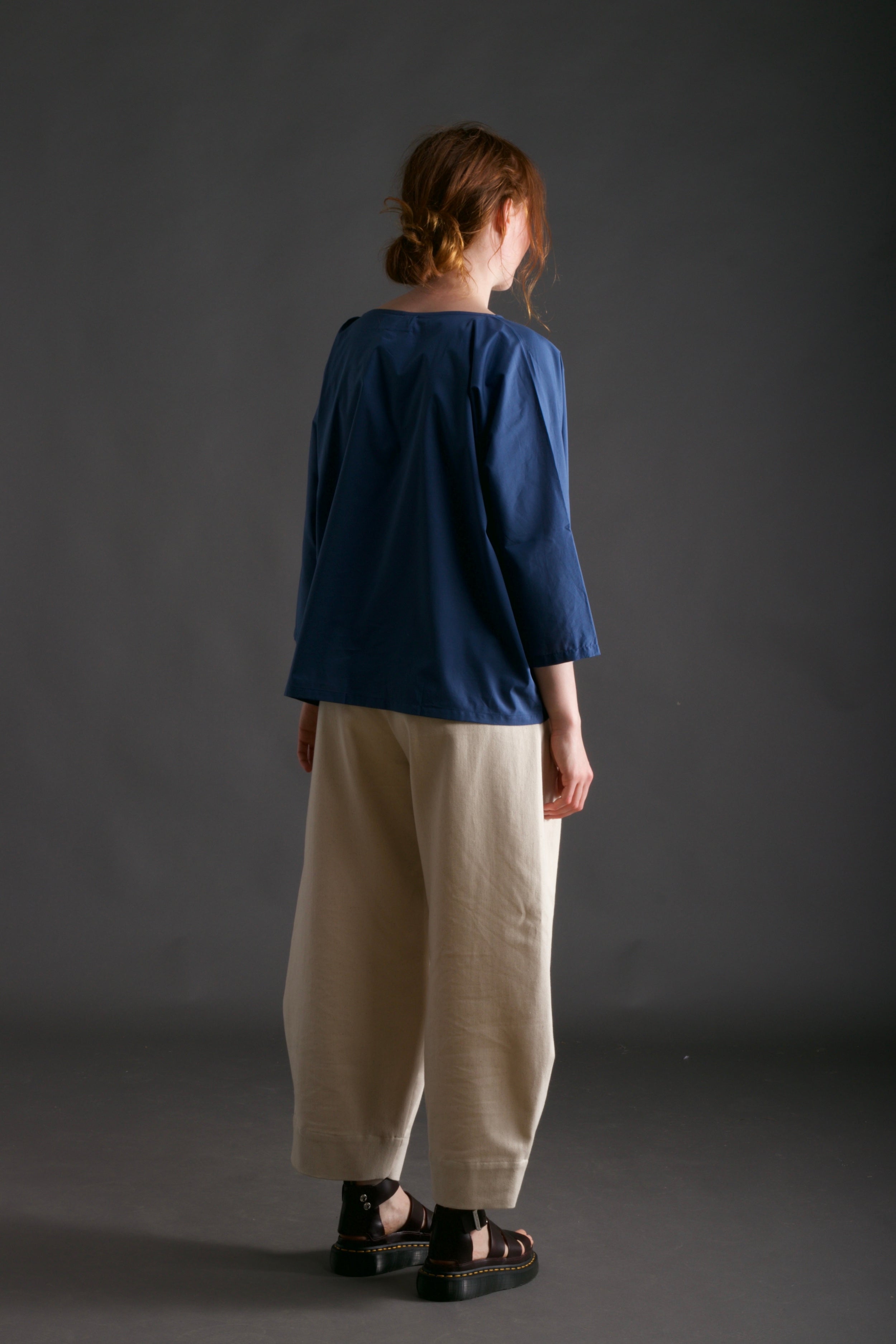 Woman wears Carrier Company Cotton Tee Shirt in Petrol Blue with Dutch Trouser in Seeded Denim