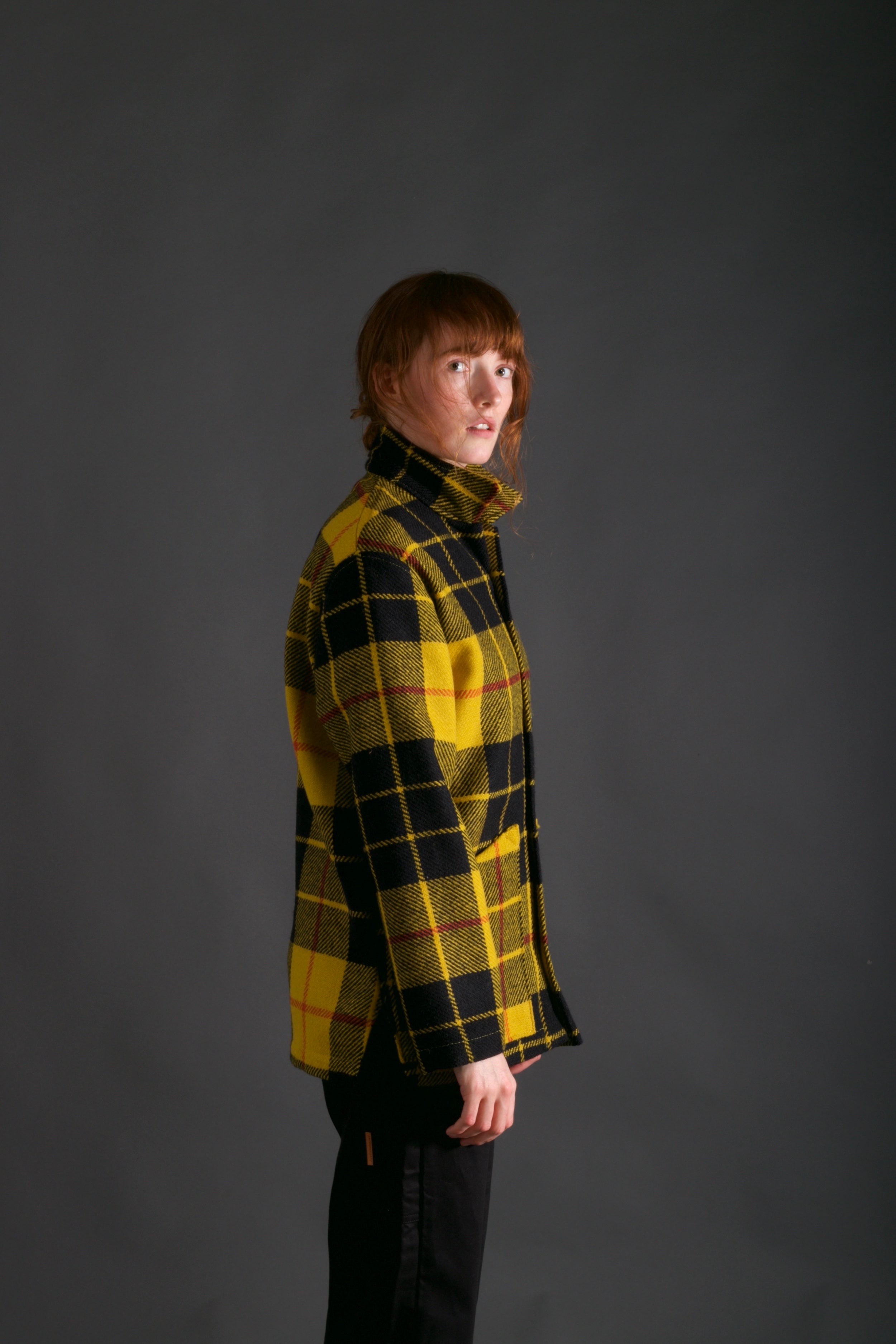 Woman wears Carrier Company Celtic Wool Jacket in Black and Yellow with Women's Dungarees in Black