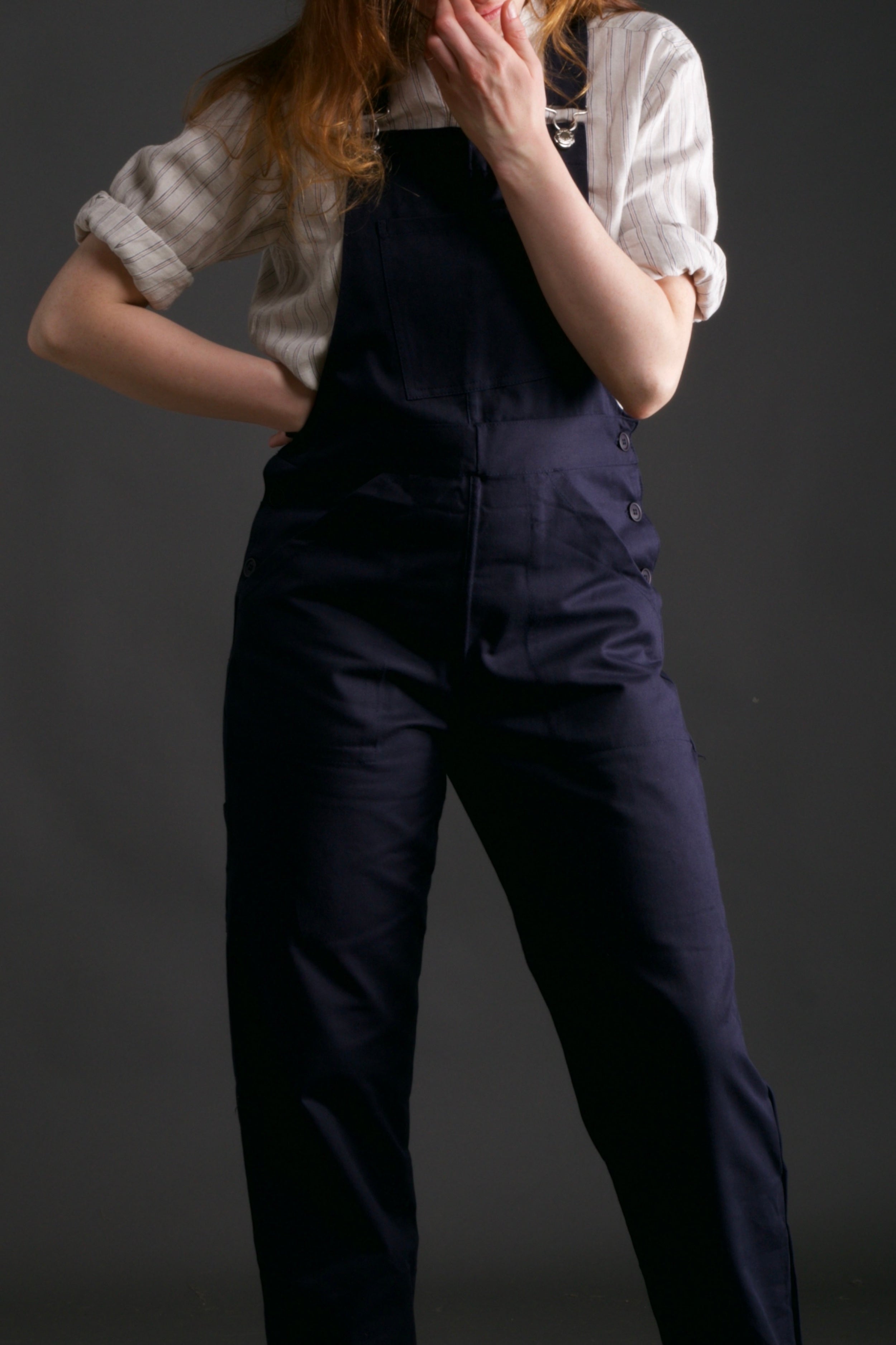 Woman wears Carrier Company Women's Dungarees in Navy with Linen Collarless Work Shirt