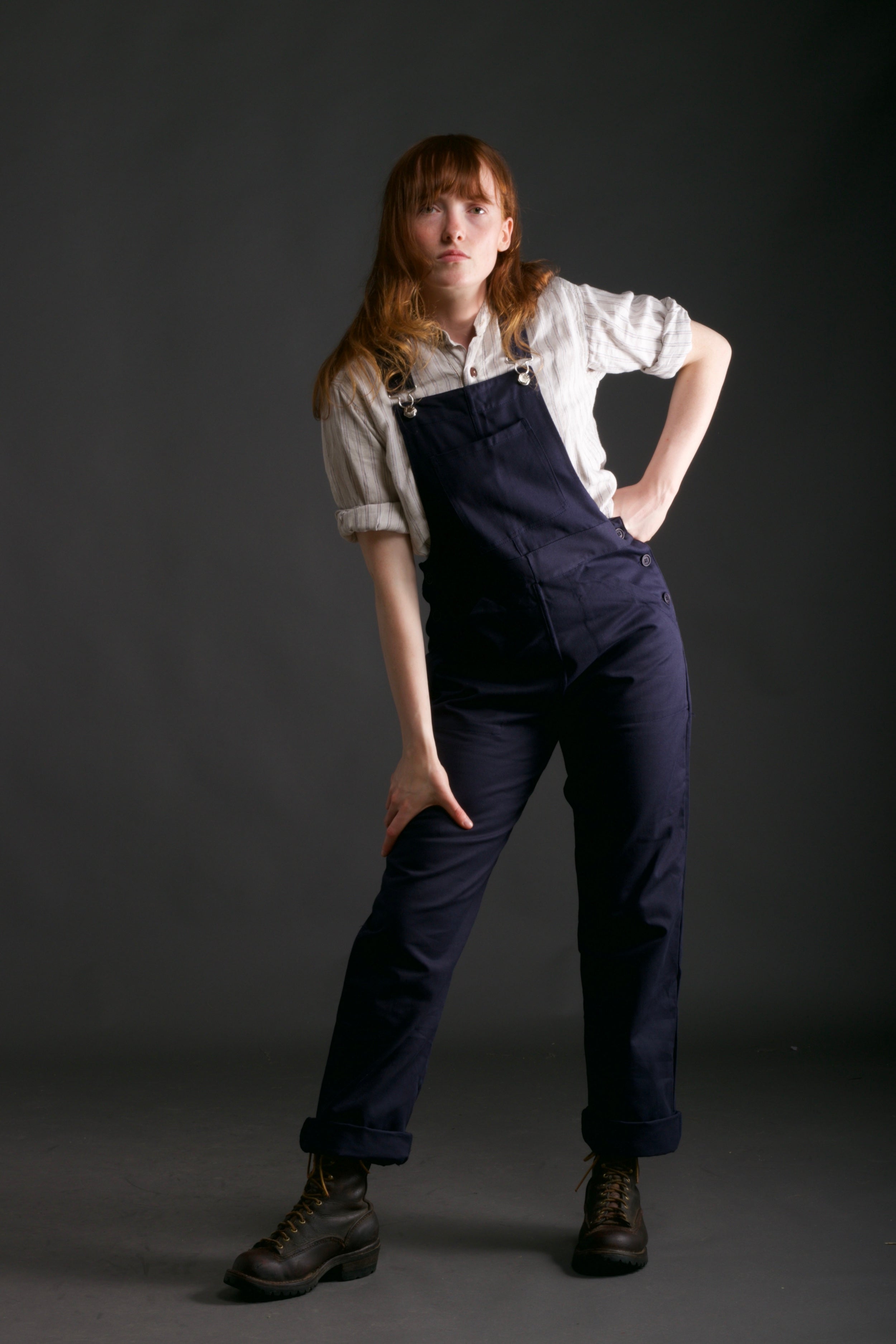 Woman wears Carrier Company Women's Dungarees in Navy with Linen Collarless Work Shirt