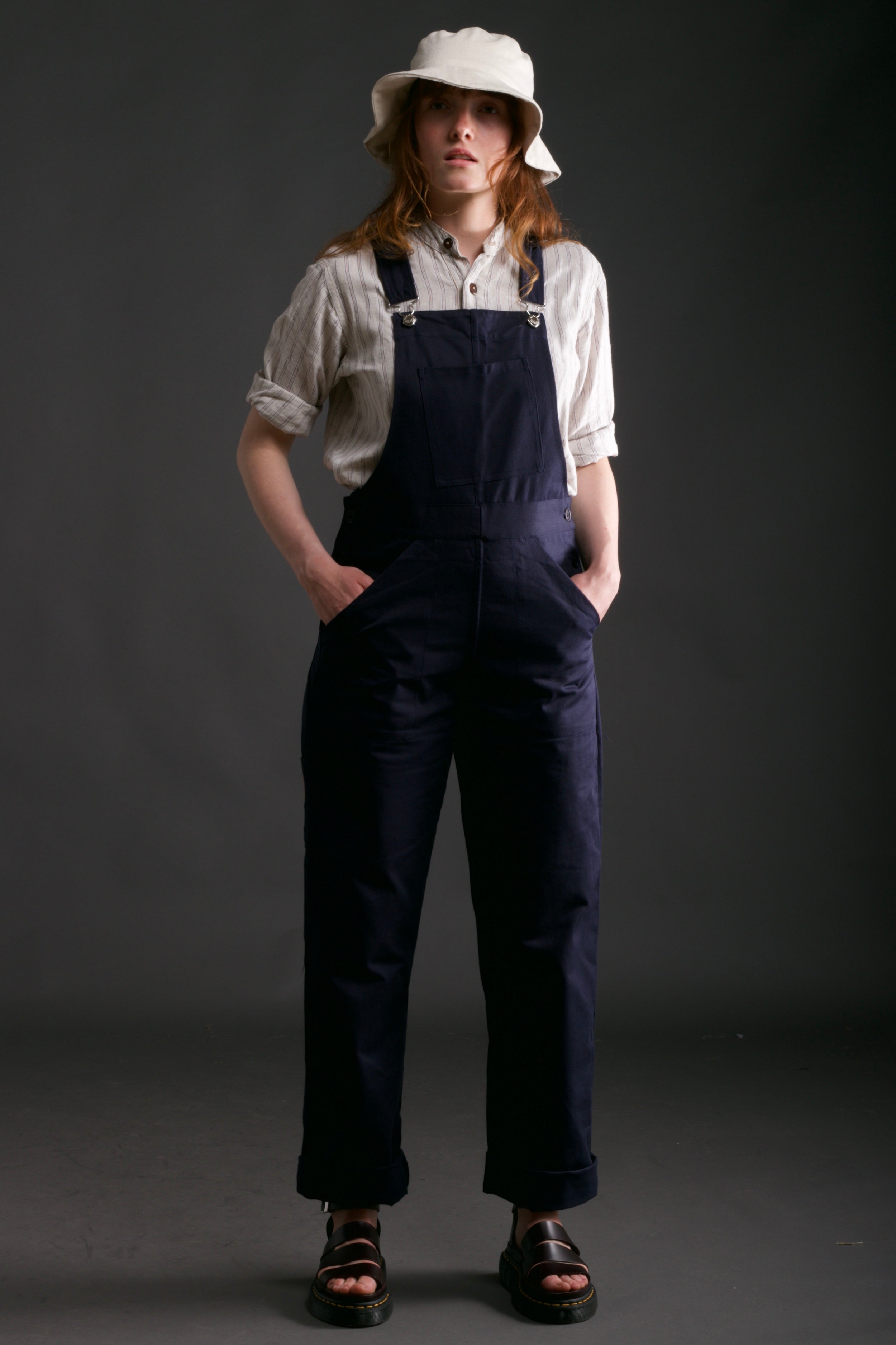 Woman wears Carrier Company Women's Dungarees in Navy with Linen Collarless Work Shirt