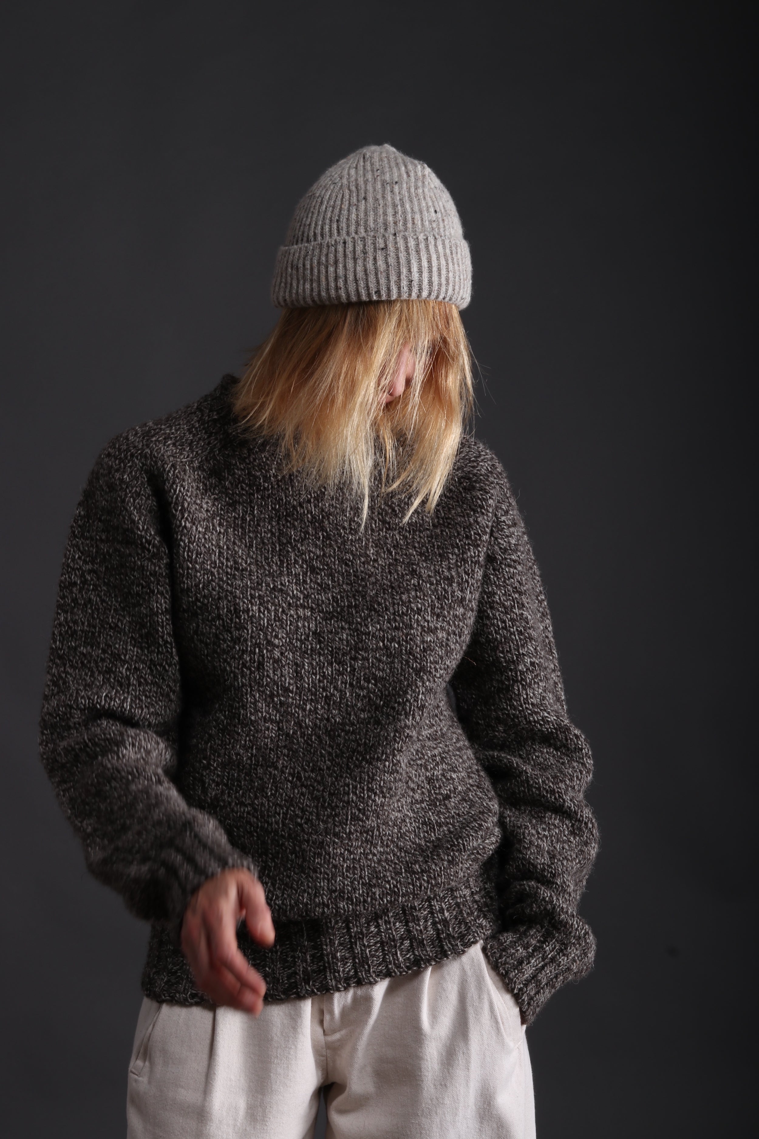 Woman wears Carrier Company Heavy Heritage Breed Lambswool Jumper with Donegal Wool Hat and Dutch Trouser in Seeded Denim