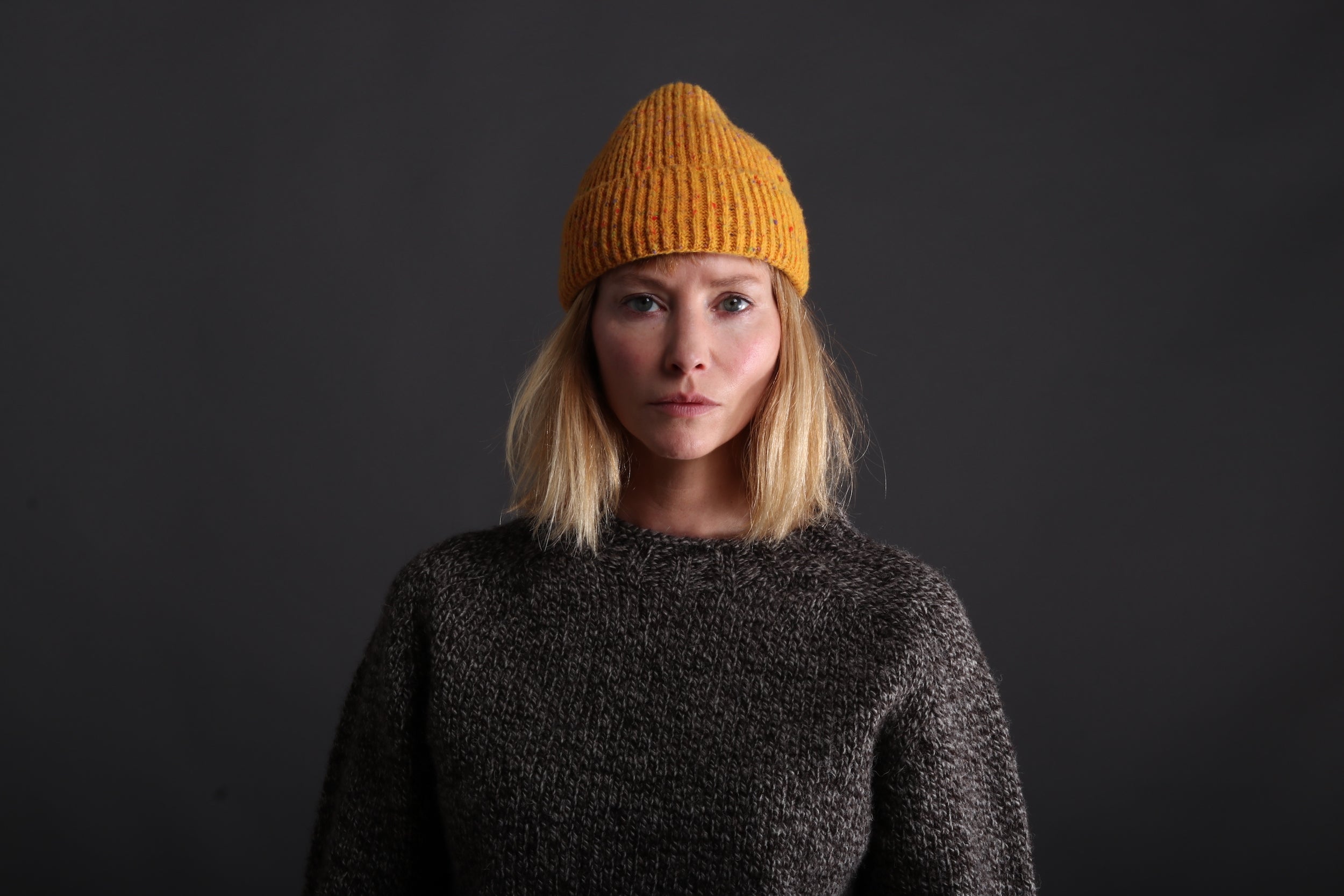 Woman wears Donegal Wool Hat  in Papaya with Heavy Heritage Breed Lambswool Jumper