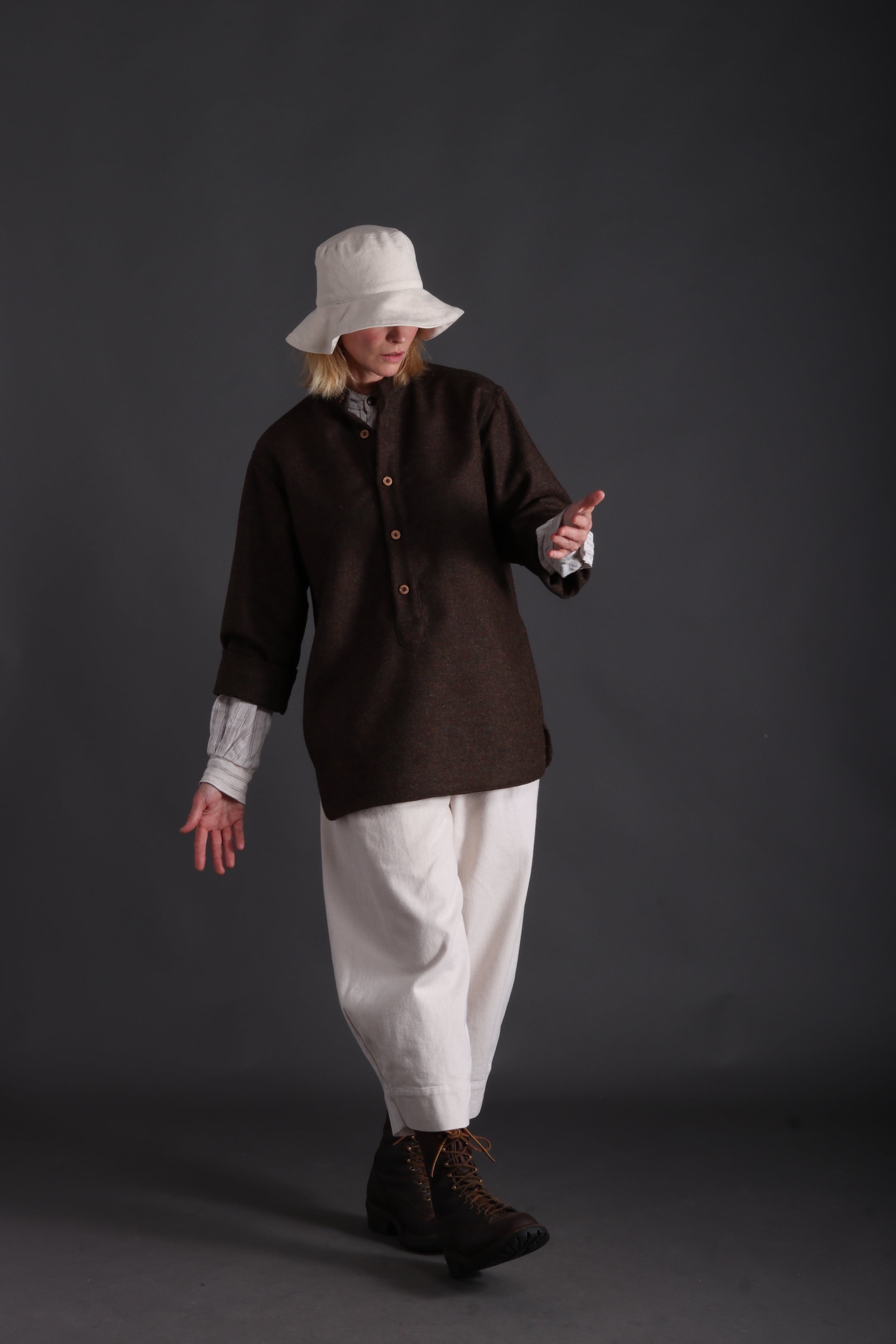 Woman wears Carrier Company Overshirt with Striped Linen Collarless Shirt, Dutch Trouser in Seeded Denim and Cotton Sun Hat