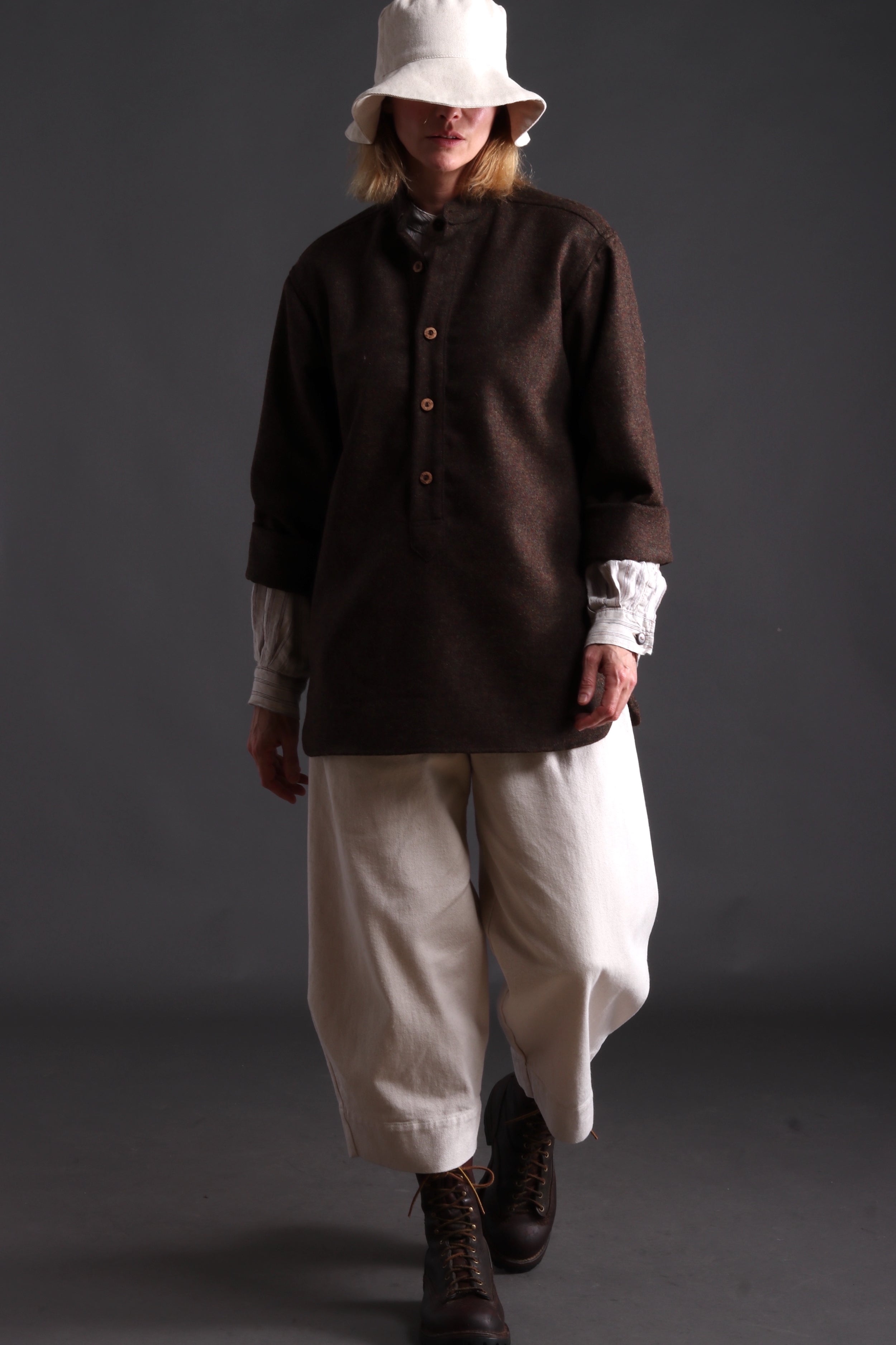 Woman wears Carrier Company Overshirt with Striped Linen Collarless Shirt, Dutch Trouser in Seeded Denim and Cotton Sun Hat