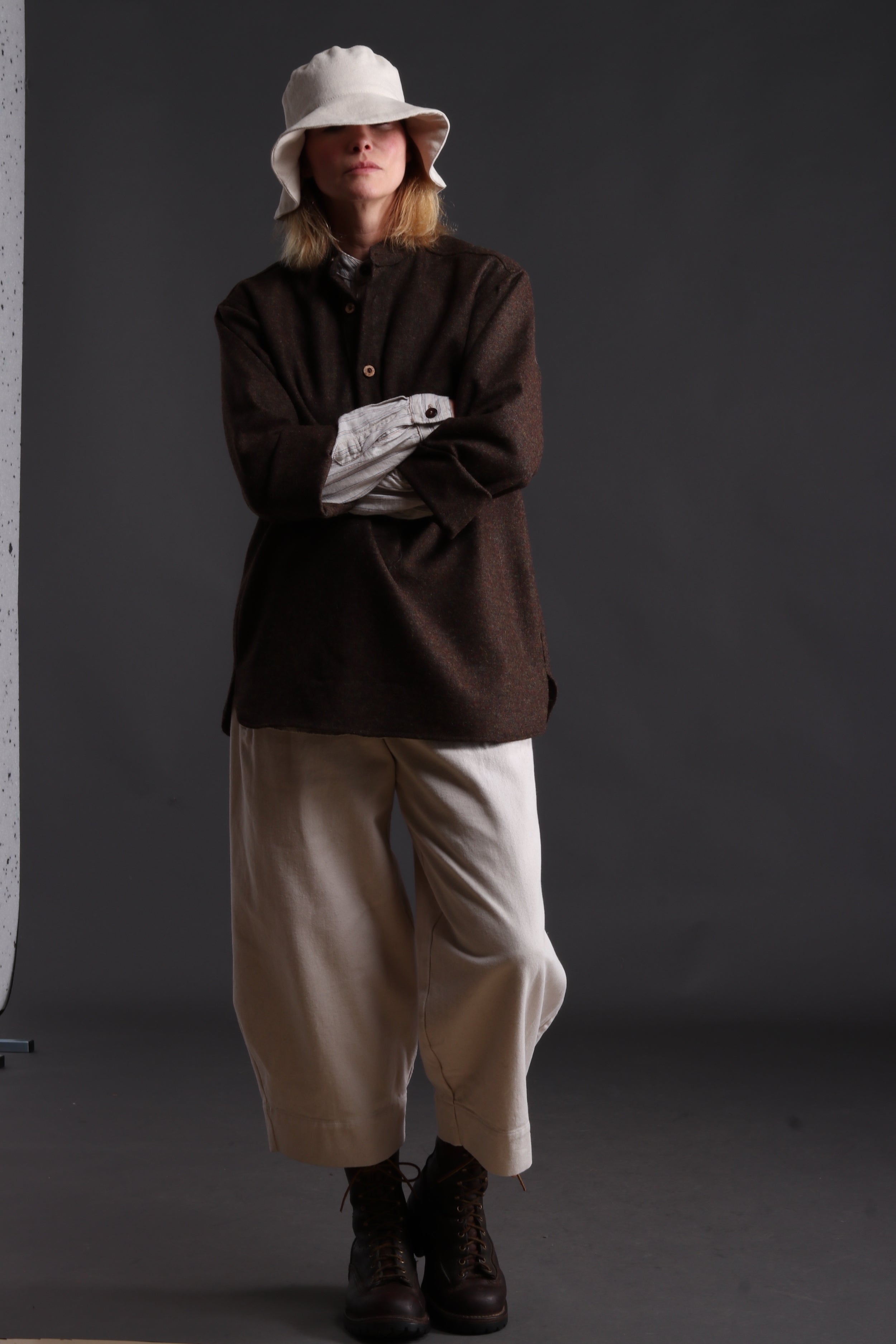 Woman wears Carrier Company Overshirt with Striped Linen Collarless Shirt, Dutch Trouser in Seeded Denim and Cotton Sun Hat