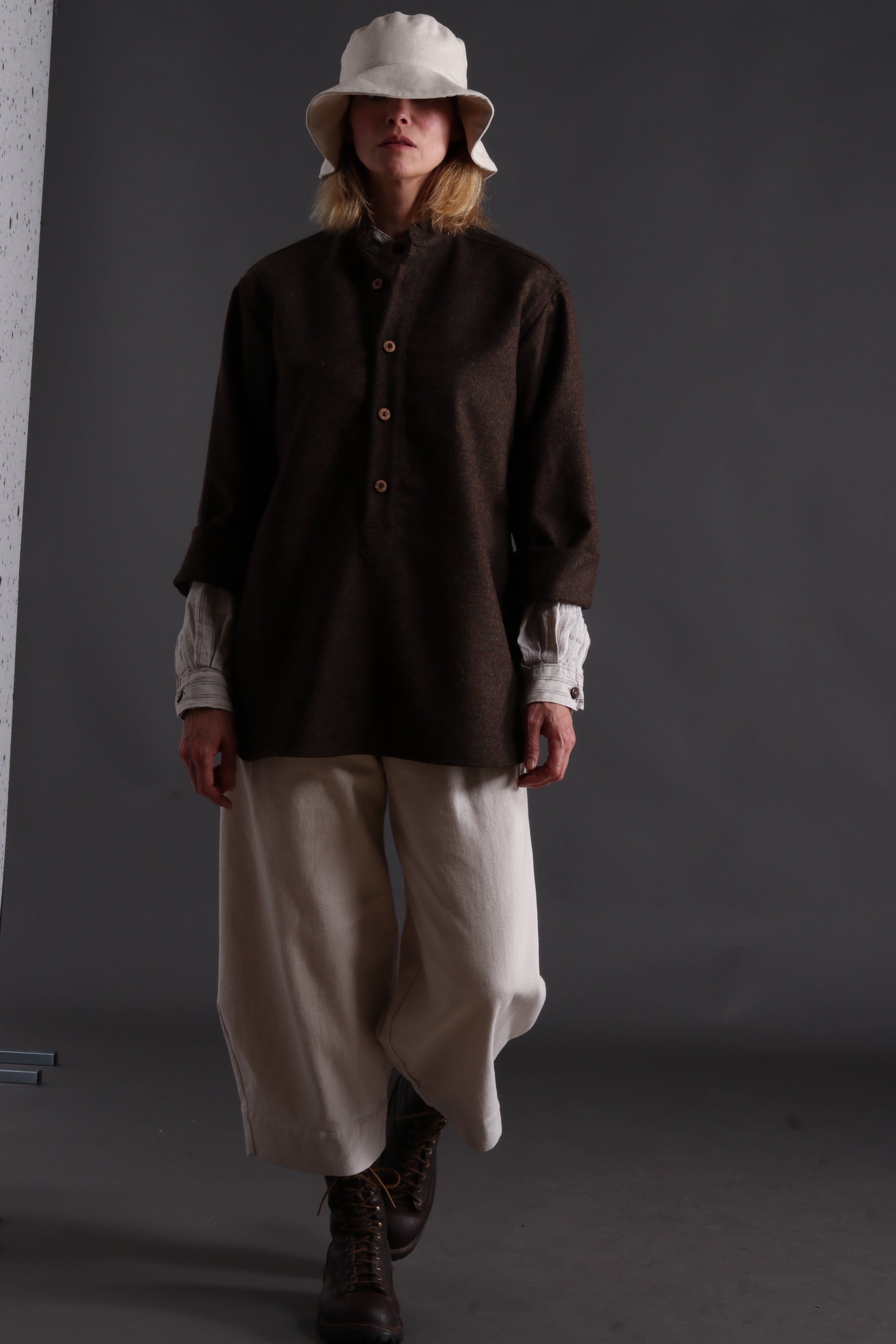 Woman wears Carrier Company Overshirt with Striped Linen Collarless Shirt, Dutch Trouser in Seeded Denim and Cotton Sun Hat