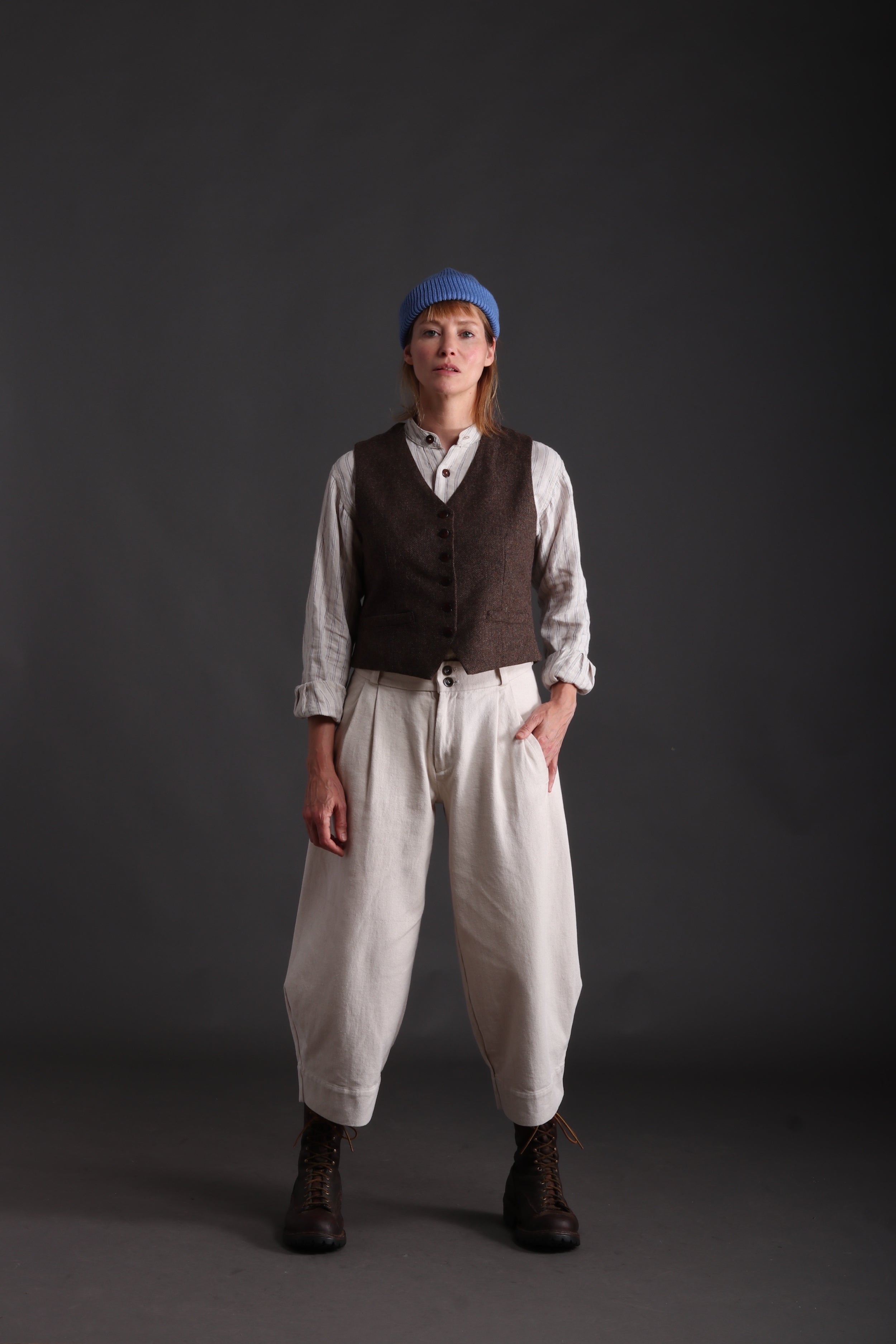 Woman wears Carrier Company Women's Wool Waistcoat in brown with Linen Collarless Worksheet and Dutch trouser in Seeded Denim