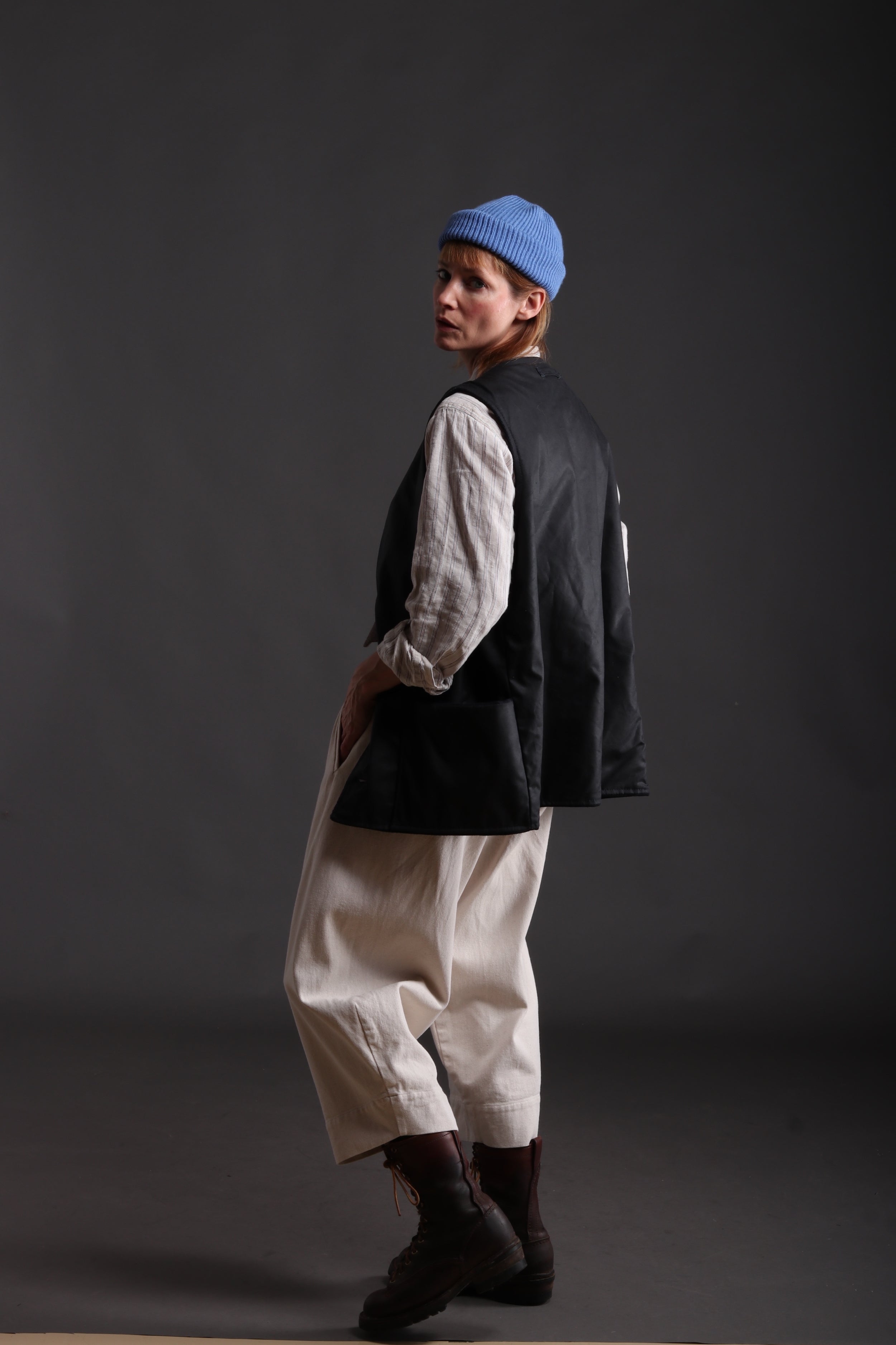 Sienna wears Carrier Company Wax Cotton Jerkin with linen collarless Work Shirt, Dutch Trouser in Seeded Denim and Wool Hat in Sky