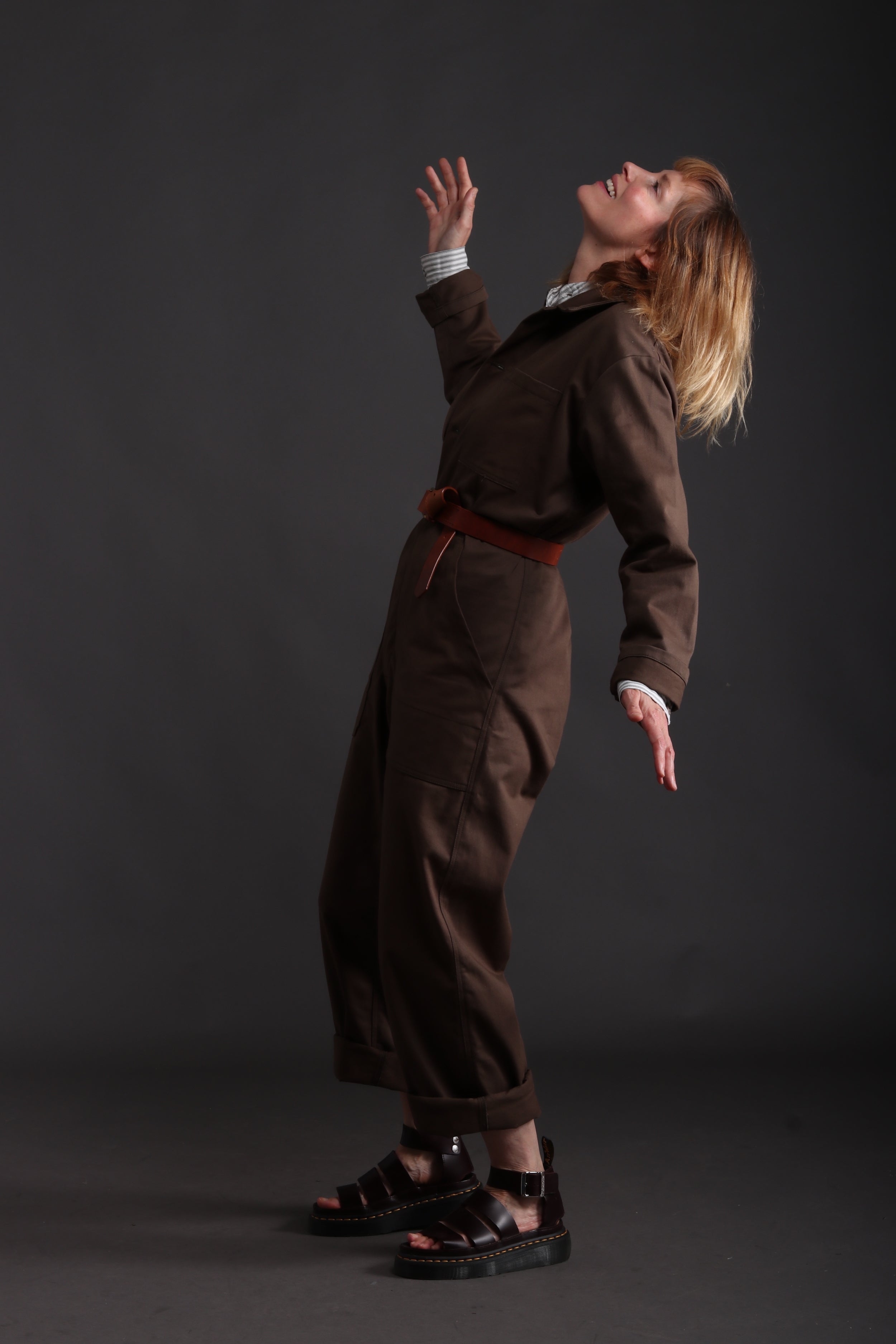 Sienna wears Carrier Company Boiler Suit in Olive Drill with Collarless Work Shirt in Ticking, Wool Hat and Chestnut Leather Belt