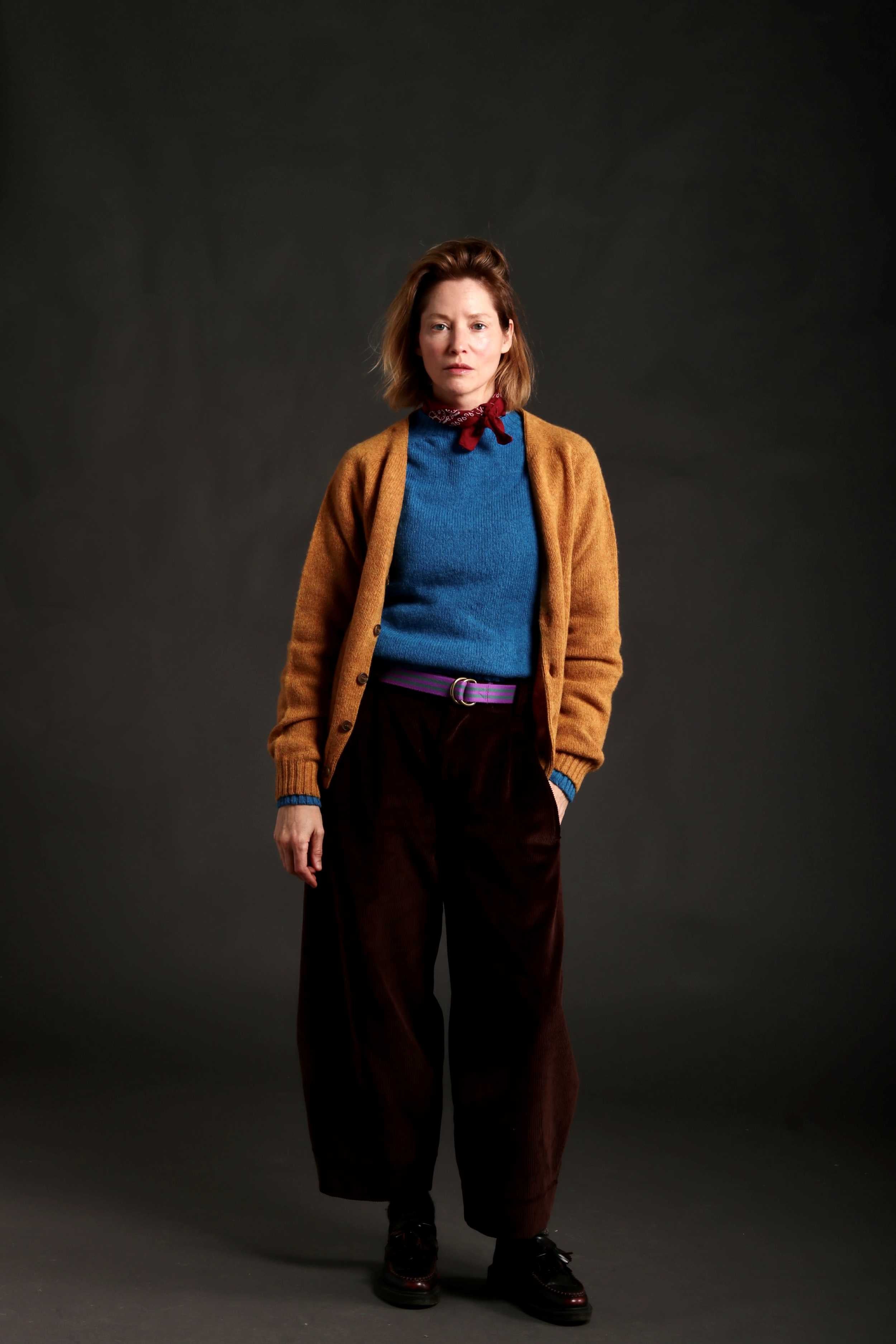 Woman Wears V Neck Button Down Cardigan in Cumin with Shetland Lambswool Jumper in Cyan and Dutch Trouser in Corduroy