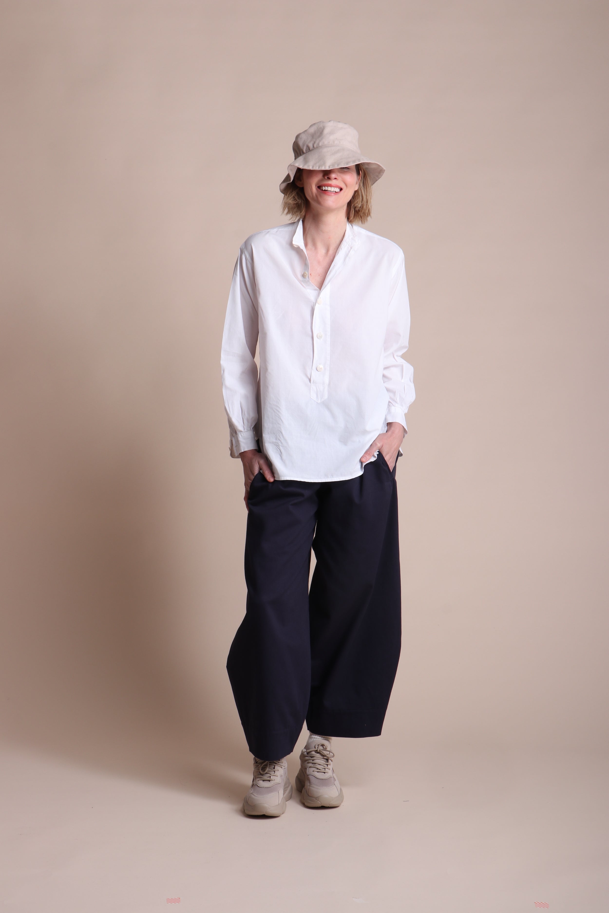Woman wears Carrier Company Lightweight Collarless Shirt with Dutch Trouser In Navy Drill and Cotton Sun Hat