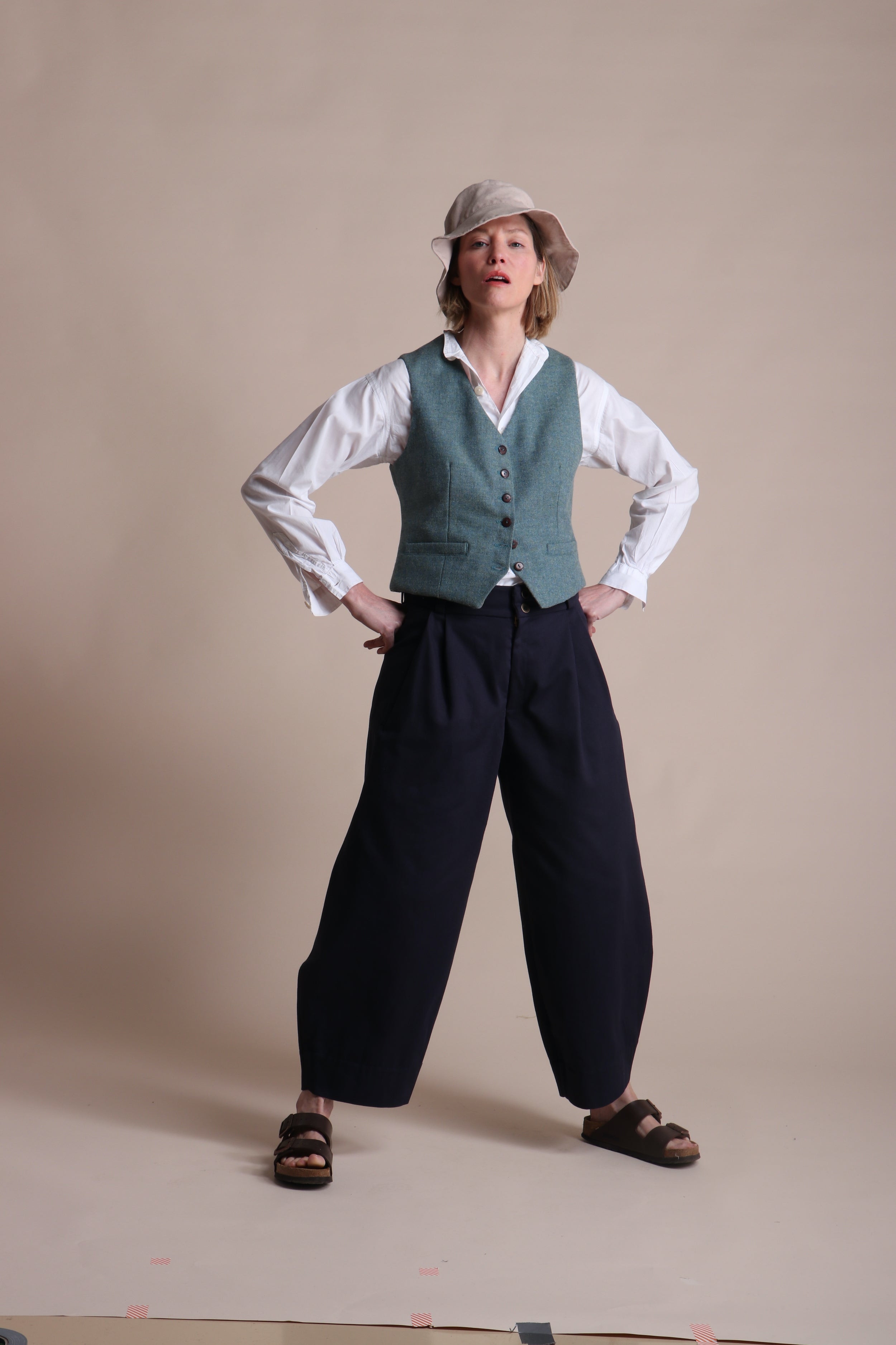 Woman wearing Carrier Company Dutch trouser In Navy Cotton Drill  with Lightweight Collarless Shirt & Men's Wool Waistcoat