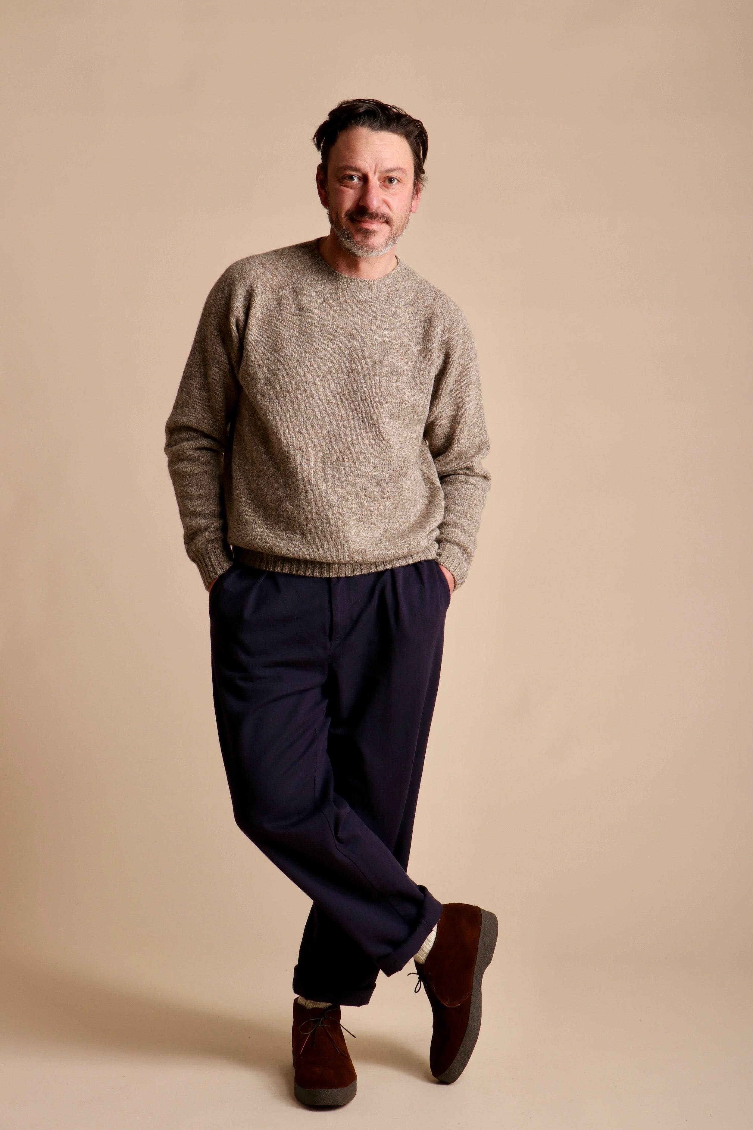 Man wears Carrier Company Classic Trouser in Navy Drill with Shetland Lambswool Jumper