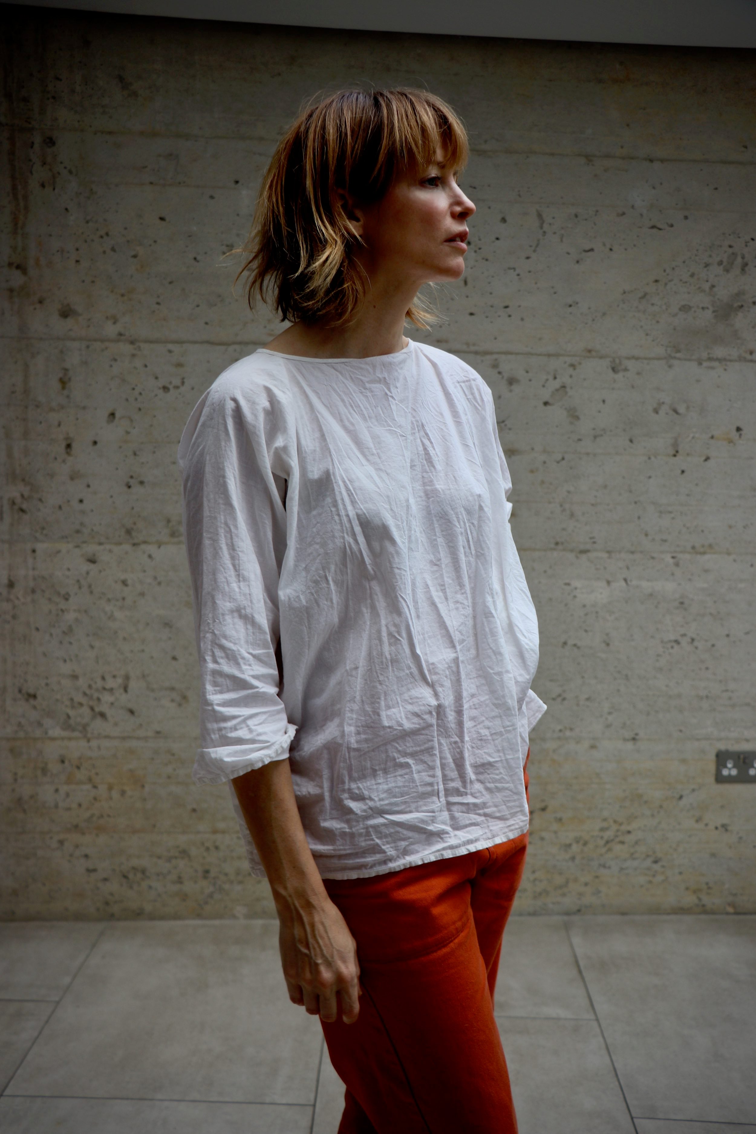 Woman wears Carrier Company White Cotton Tee Shirt with Women's Work trouser in Orange