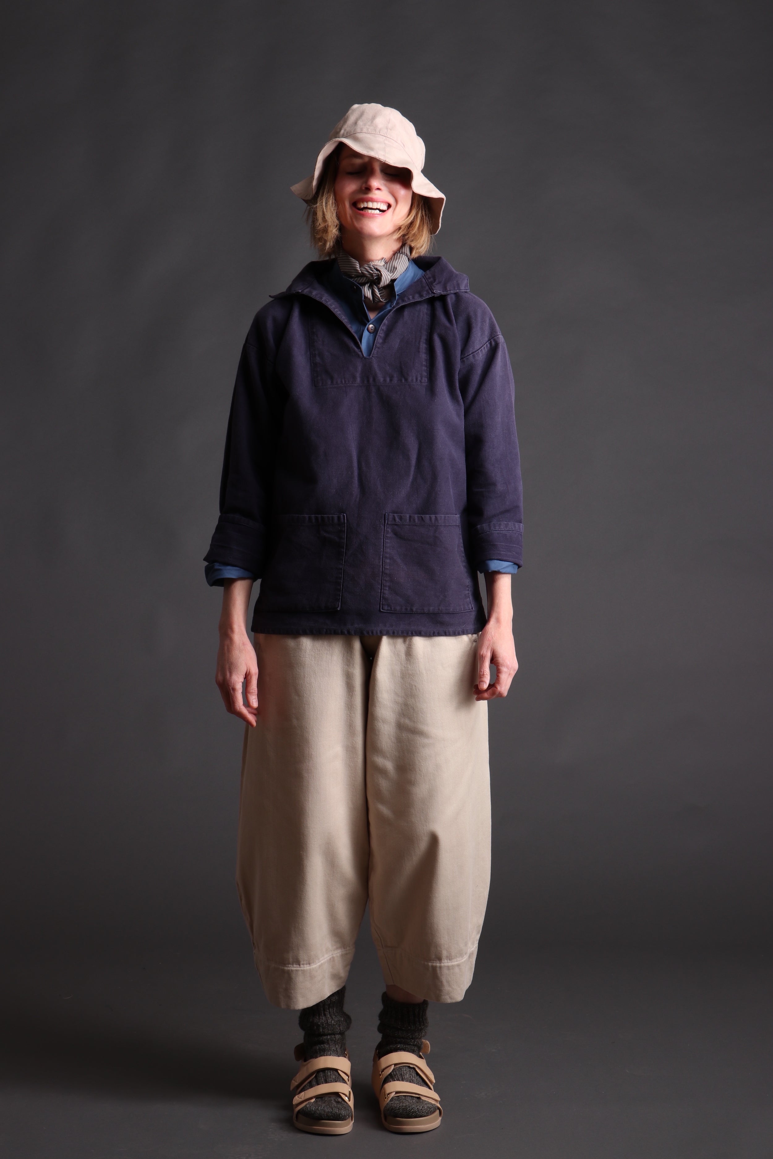 Woman wearing Carrier Company V-Neck Smock in Navy Cotton Drill with Collarless Works Shirt and Dutch Trouser