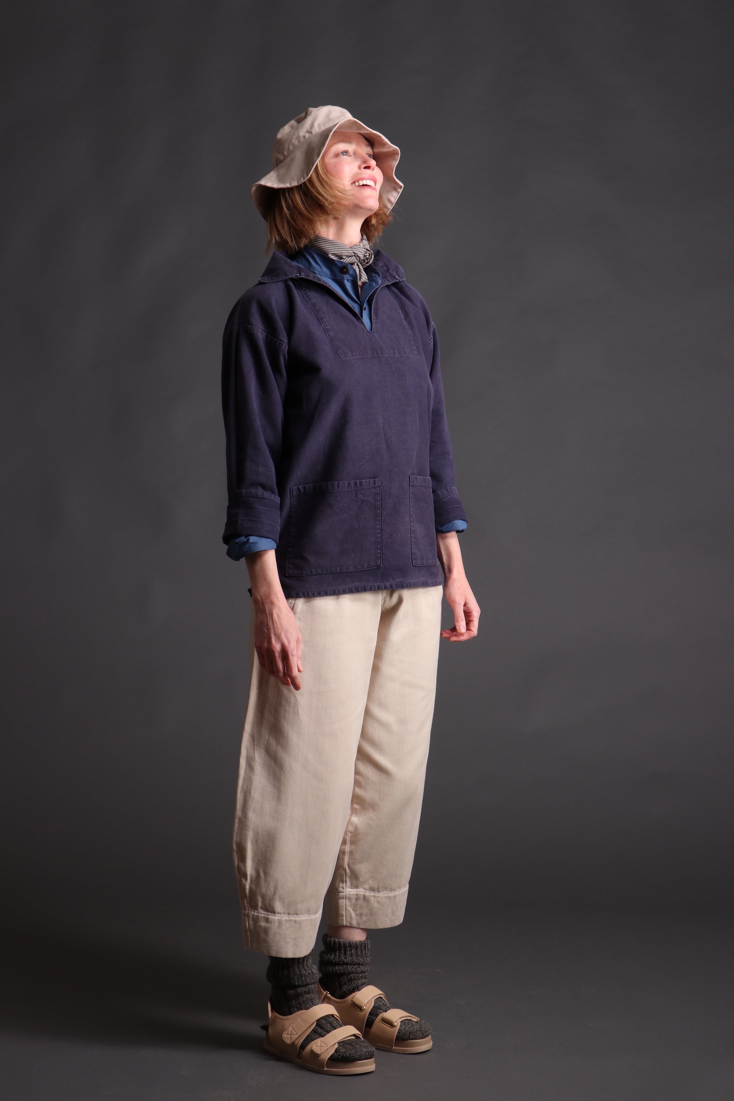 Woman wearing Carrier Company V-Neck Smock in Navy Cotton Drill with Cotton Sun Hat and Dutch Trouser