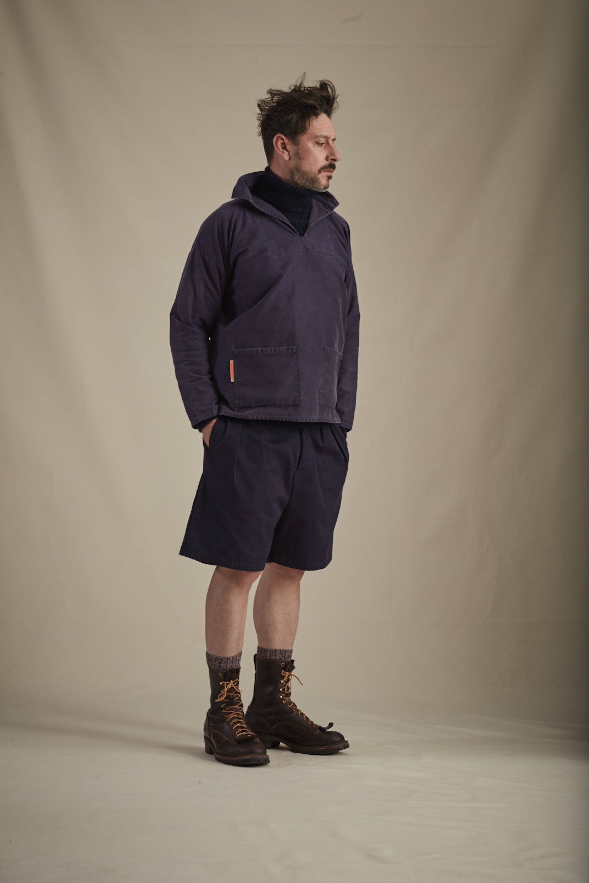 Man wearing Carrier Company V-Neck Smock in Navy Cotton Drill with Navy Grandpa Shorts