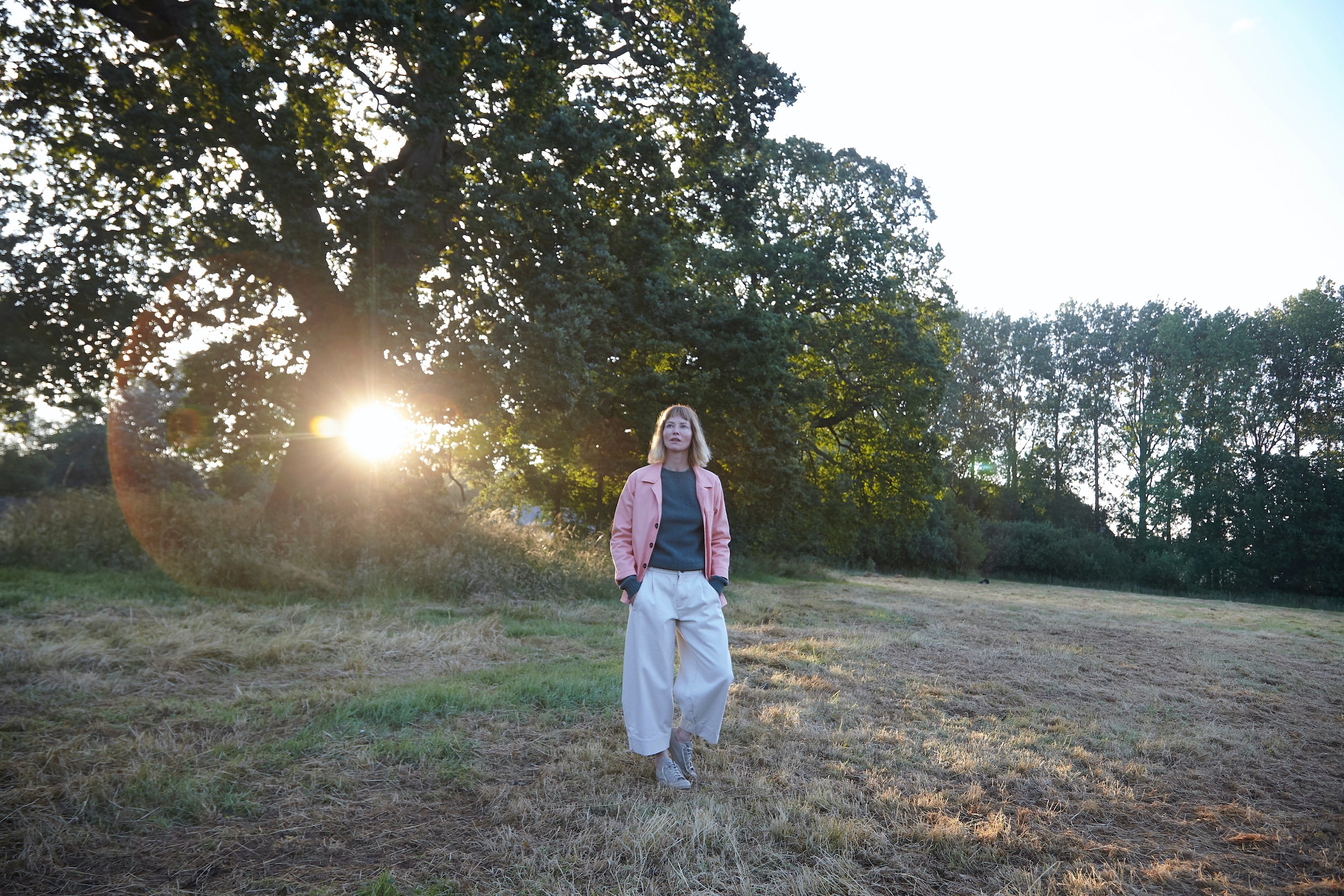 Woman wears Carrier Company Dutch Trouser in Seeded Denim with Shetland Lambswool Jumper and Panama Sailcloth Work jacket in Cantaloupe