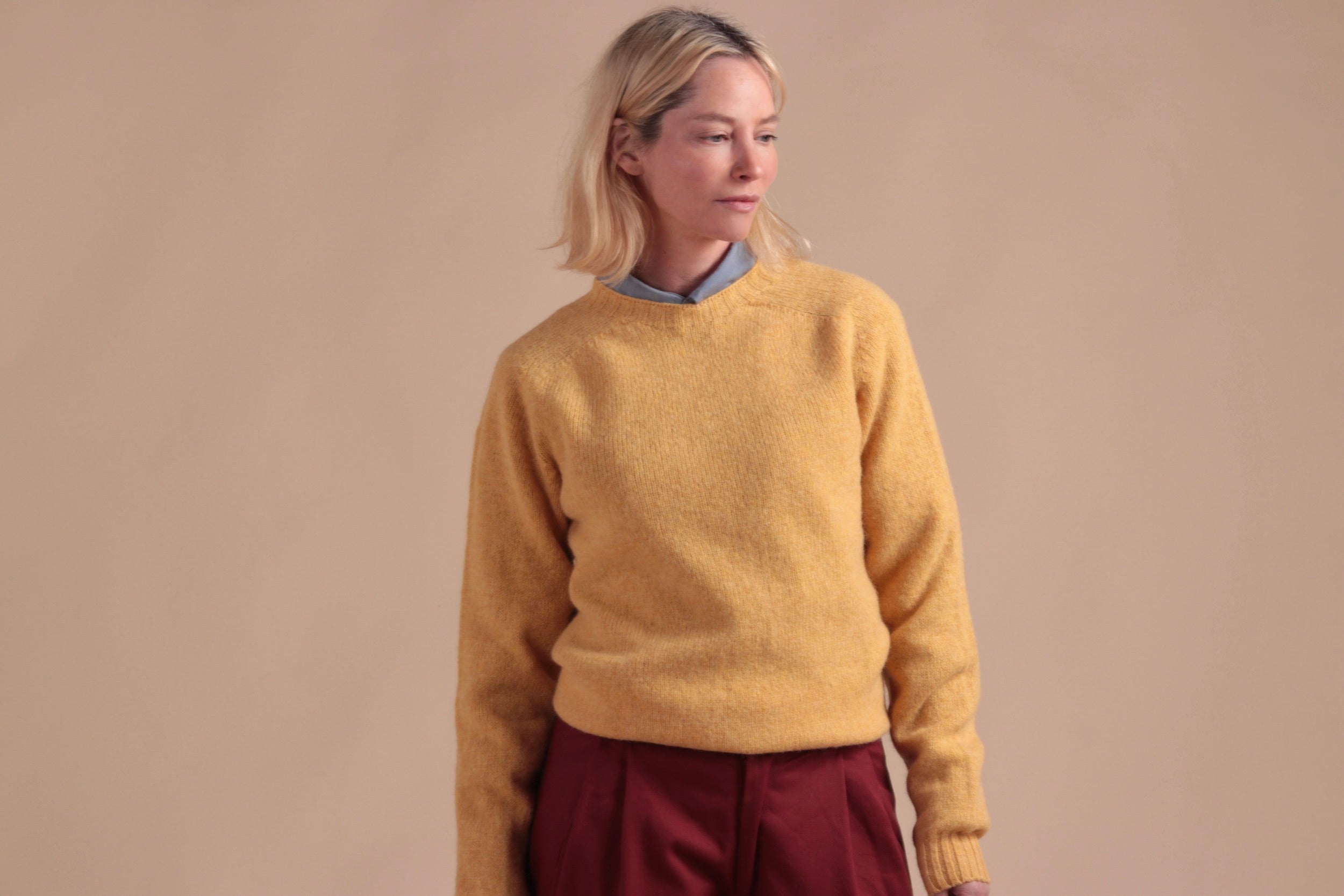 Woman wearing Carrier Company Shetland Lambswool Jumper in Chamomile with Breton Red Dutch Trouser in Cotton Drill